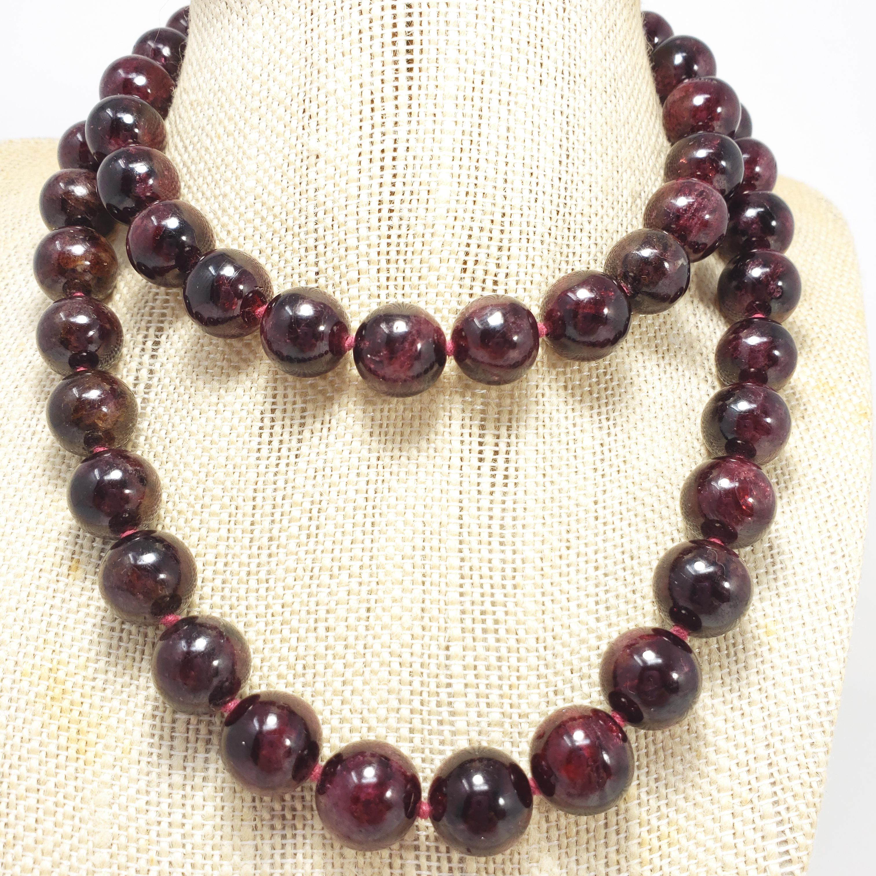 An exquisite necklace featuring polished garnet beads on a knotted string necklace. Fastened with a sterling silver S hook clasp. Bold, striking, dark color!

Bead diameter approx 12.5mm
Hallmarks: S 925