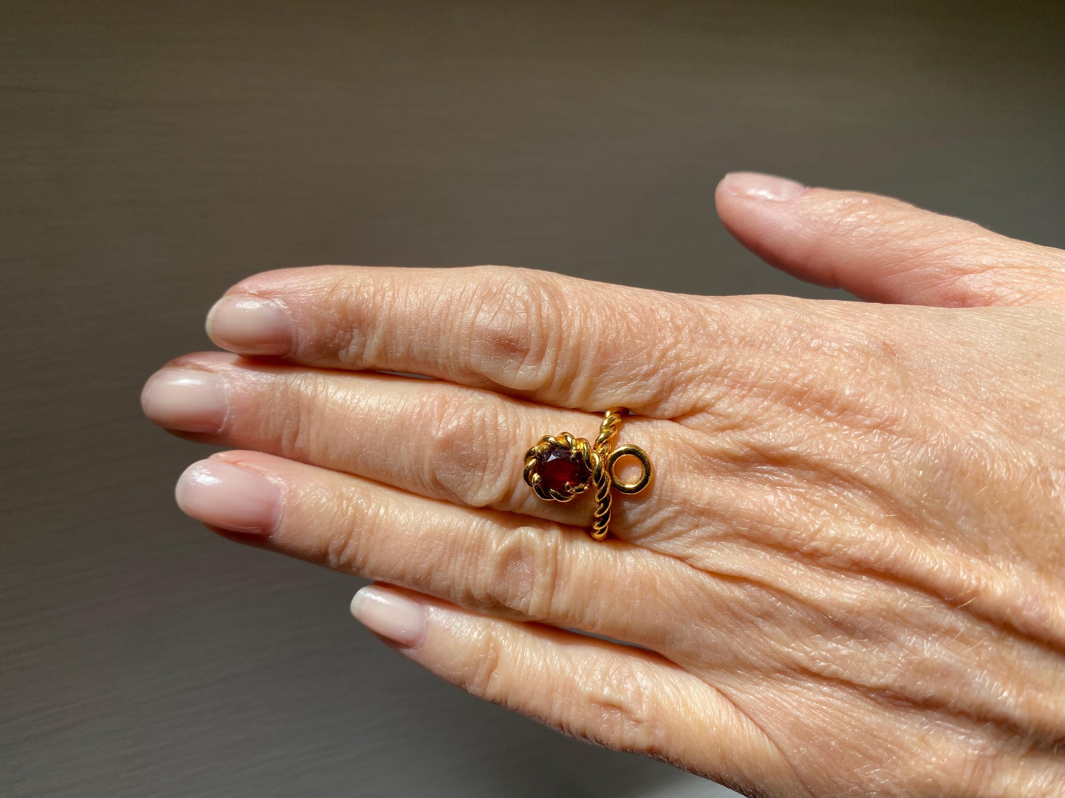 Rossella Ugolini Design Collection a beautiful pear cut Garnet Design, Ring handcrafted in a 18 Karats Yellow Gold twisted rope that makes a single line around the finger and surrounds the deep bordeaux pear cut Garnet deep red stone. Elegant and