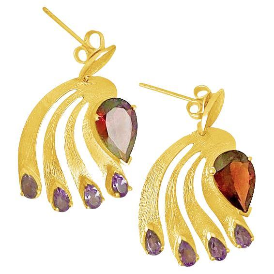 Finely crafted to artfully depict the show-stopping colors of the peacock in its full expressive form, these imaginative earrings thoughtfully couple a contemporary artistic vision with the classic elegance of garnet and amethyst. Surprising pops of