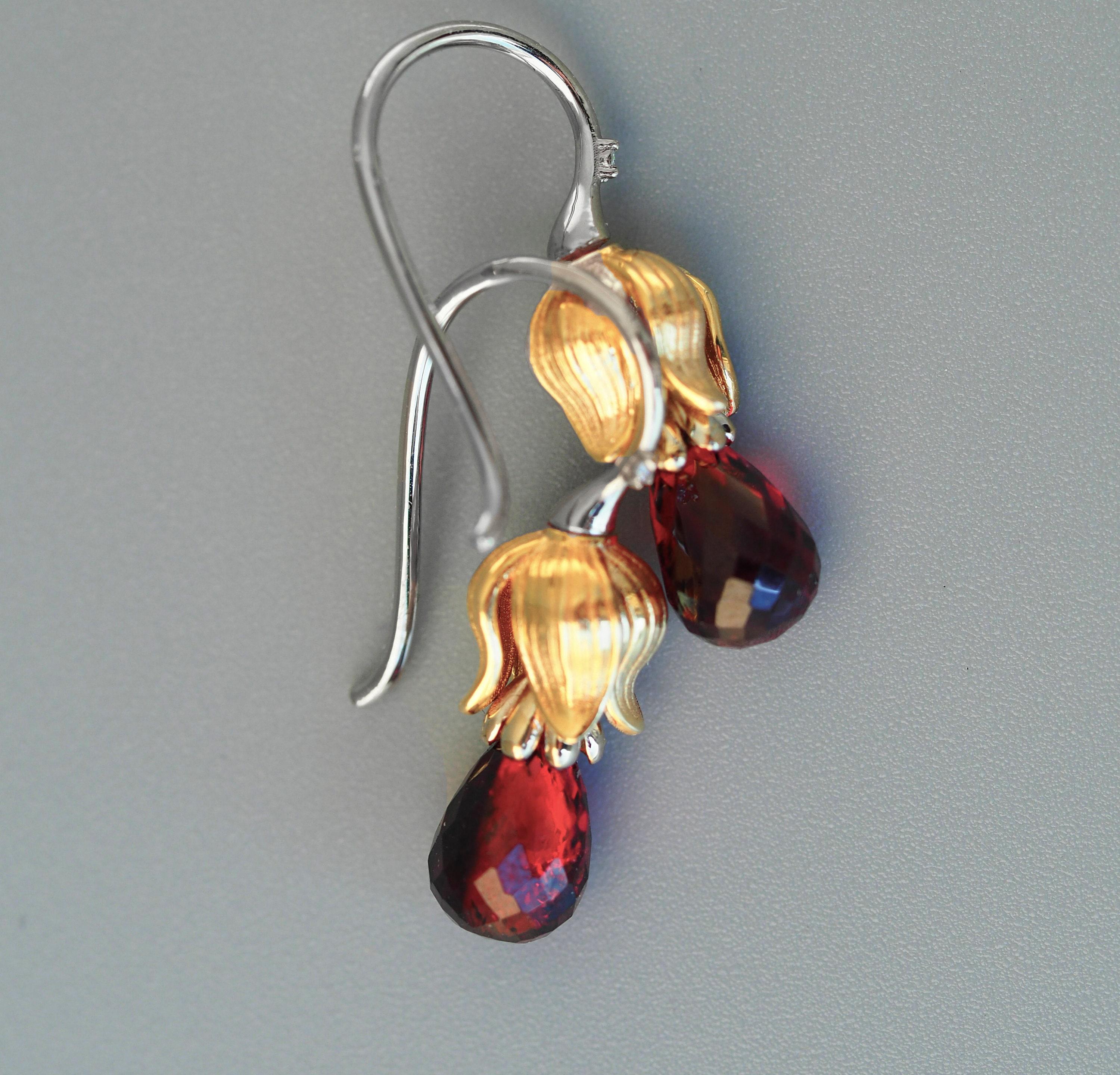 Garnet and diamonds earrings in 925 silver.

Metal: 925 silver
Weight: 3.25 g.
Size: 21x6mm. 
 
Garnets 2 pieces - red color, briolette cut, transparent, 8.5x5.7 mm each, aprx 3 ct total.
Diamonds 2 piece, 0.02 total ct, G/VS, brilliant