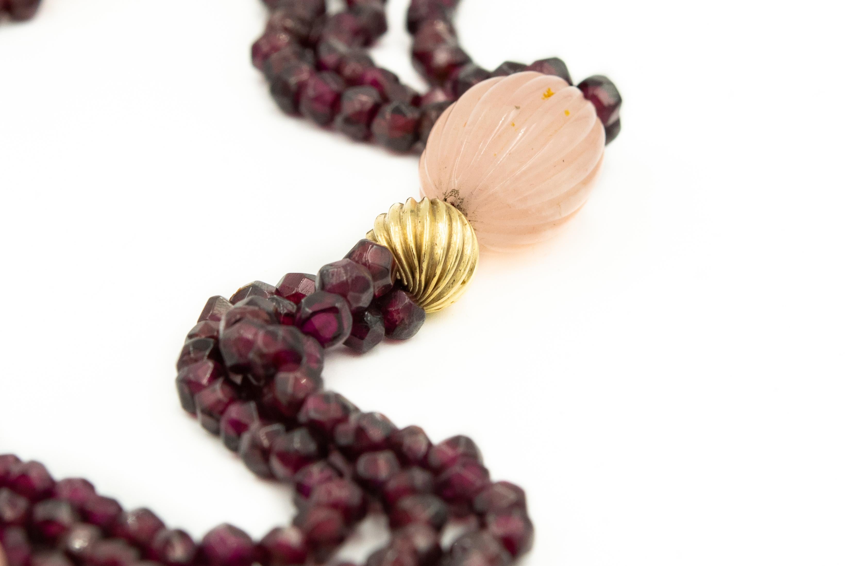 Multi-strand garnet necklace accented by fluted rose quartz beads and fluted gold filled ball.  The jump ring clasp is 12k gold filled.  The front area 5 sections have 3 strands and the last 2 near the clasp have 2 strands.