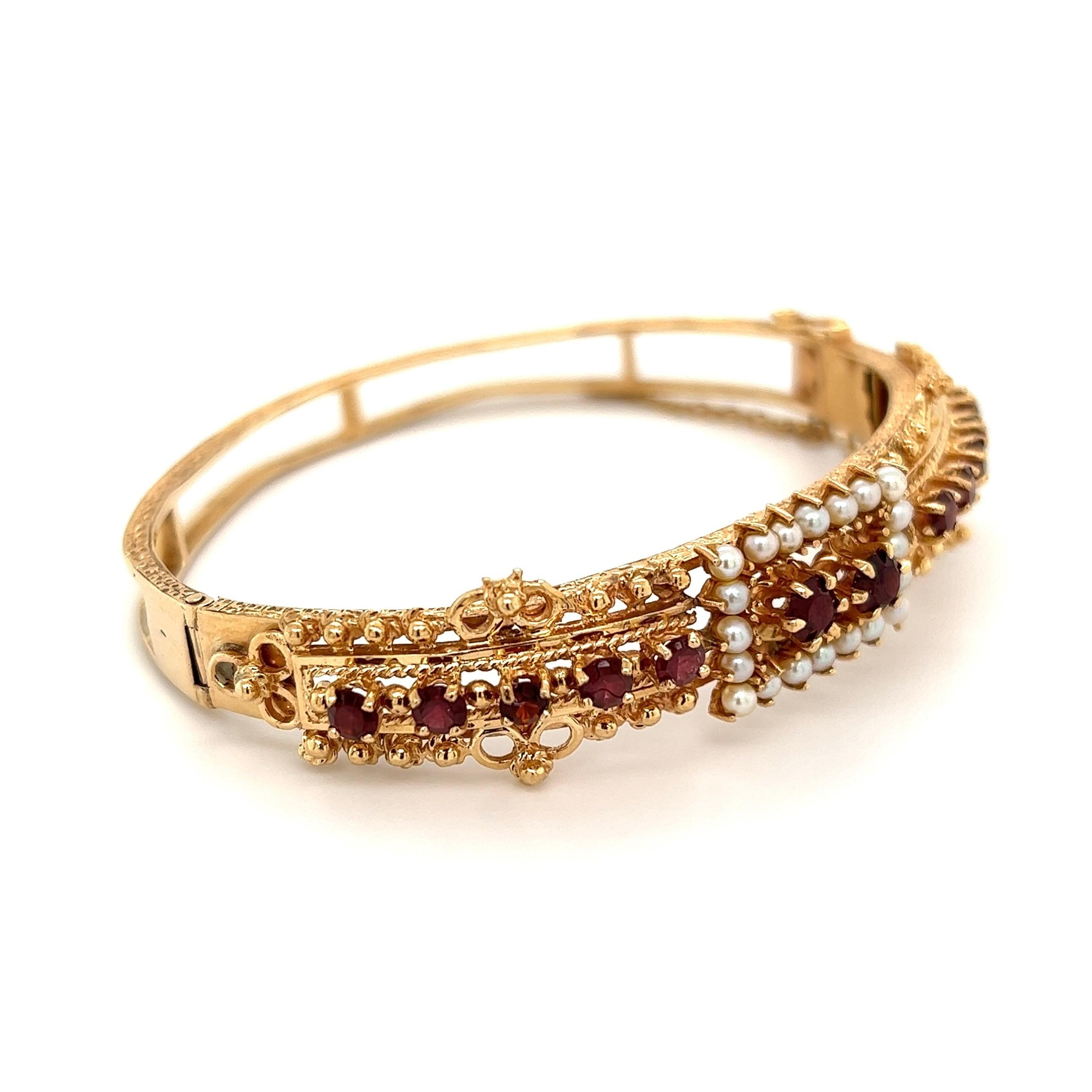 Simply Beautiful! Finely detailed Victorian Revival Hinged Cuff Bangle Bracelet. Hand set with Garnets and Seed Pearls. Hand crafted in 14 Karat Yellow Gold. Approx. Dimensions: 2.35” l x 2.66” w. The Bracelet is in excellent condition and was