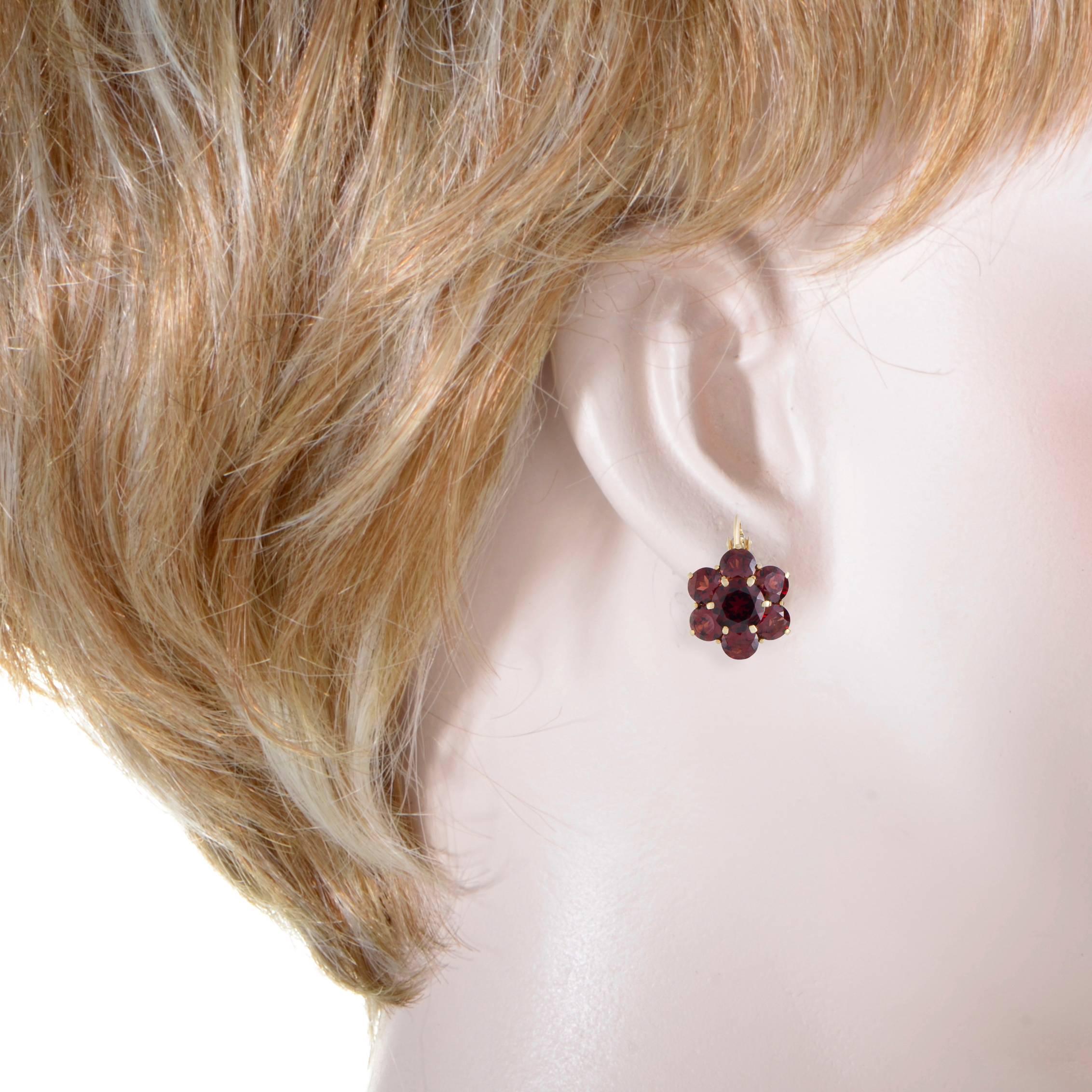 Delightfully dainty and feminine, these sublime earrings are expertly crafted from radiant 18K yellow gold and depict lovely flowers. The earrings are set with eye-catching garnets.
