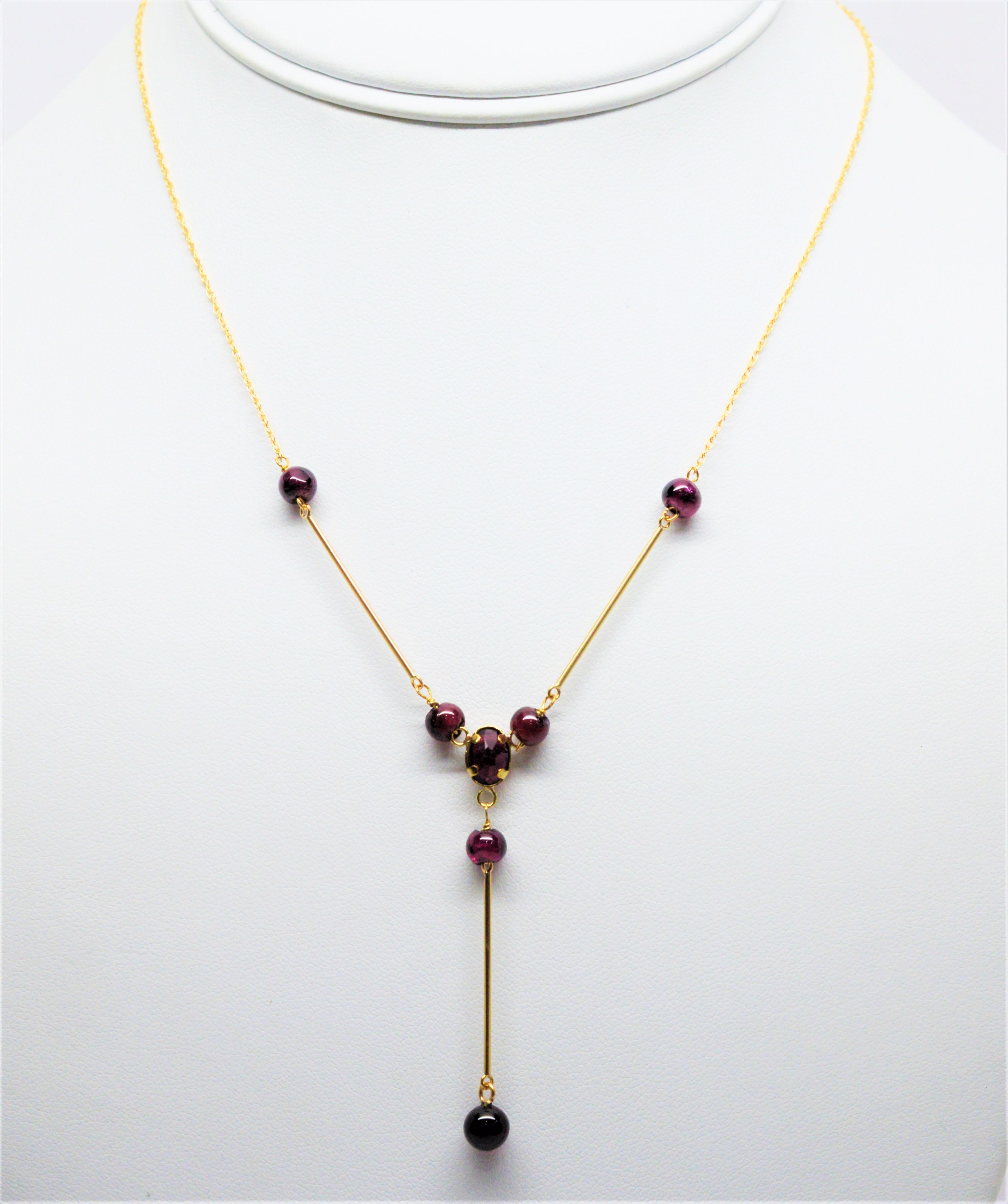 Flirty and fun with a vintage style twist.  Rich red polished round garnet beads and a center facet-cut garnet before the drop. With fourteen karat yellow gold bar links and chain, this feminine style Y necklace measures sixteen inches plus the two