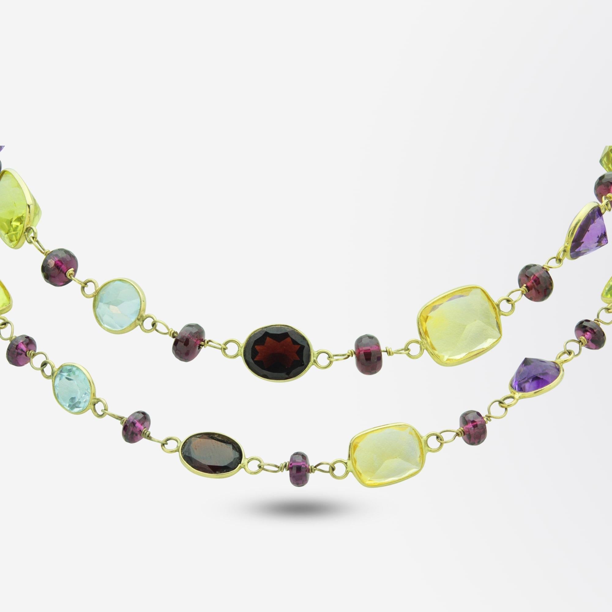 A fun and colourful opera length necklace in 14 karat gold mounted with semi precious gemstones. The necklace comprises of 50 garnets, 15 citrines, 9 amethysts and 7 topaz stones which have been spectacle rubover set on 14 karat gold wire. Whilst