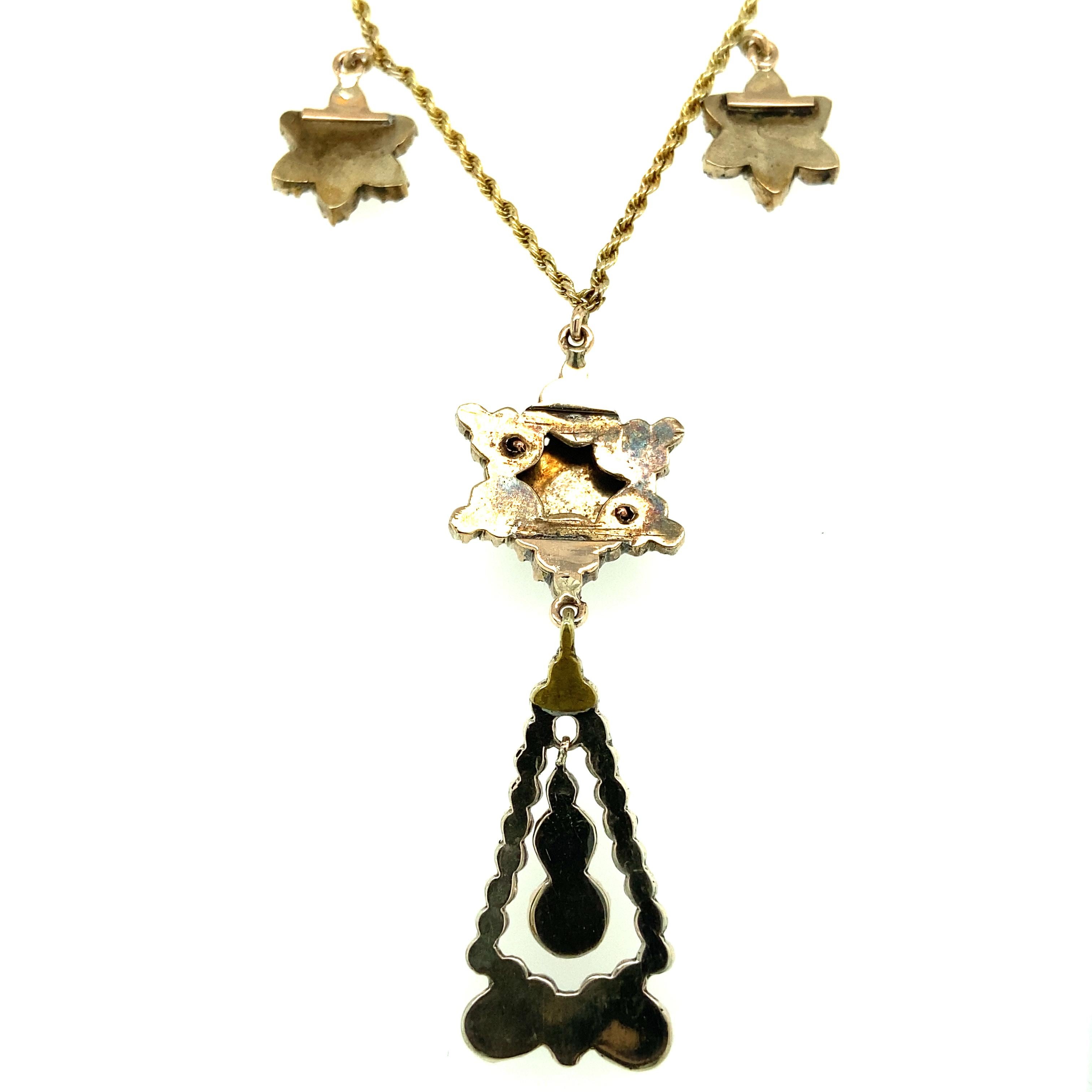One 10 karat yellow gold and silver triple cluster garnet pendant necklace,  set with seventy-six garnets. Each pendant is suspended from a 10 karat yellow gold 14 inch rope chain with barrel clasp. 
