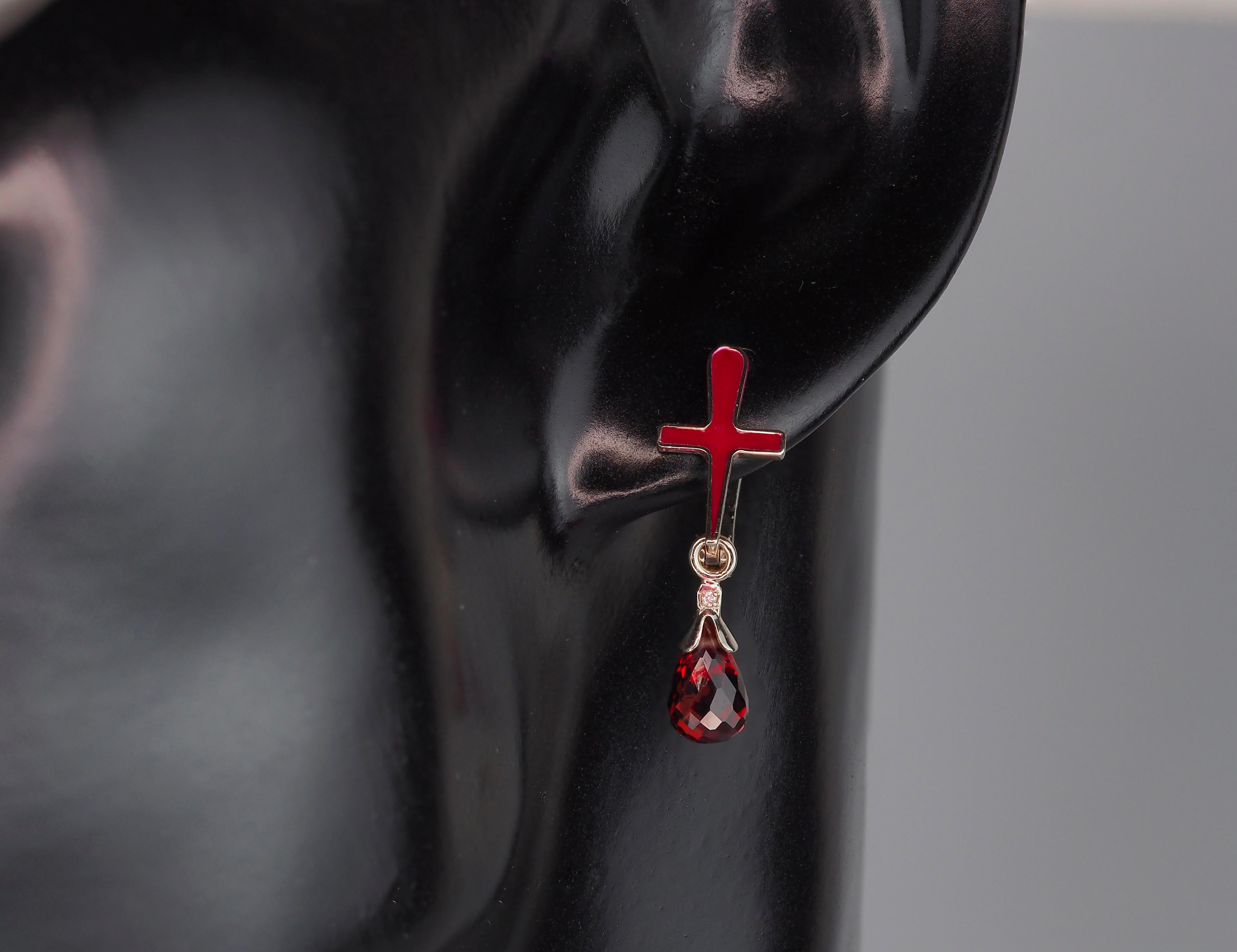 Garnet cross earrings in 14k gold. Red cross enamel earrings with garnet. Garnet briolette gold earrings.
Material: 14k gold.
Weight: 2.5 gr.
Size Earrings: 28x9 mm
Central stones: Natural Garnet - 2 pieces 
Cut: Briolette
Weight: aprx 2.4 ct.