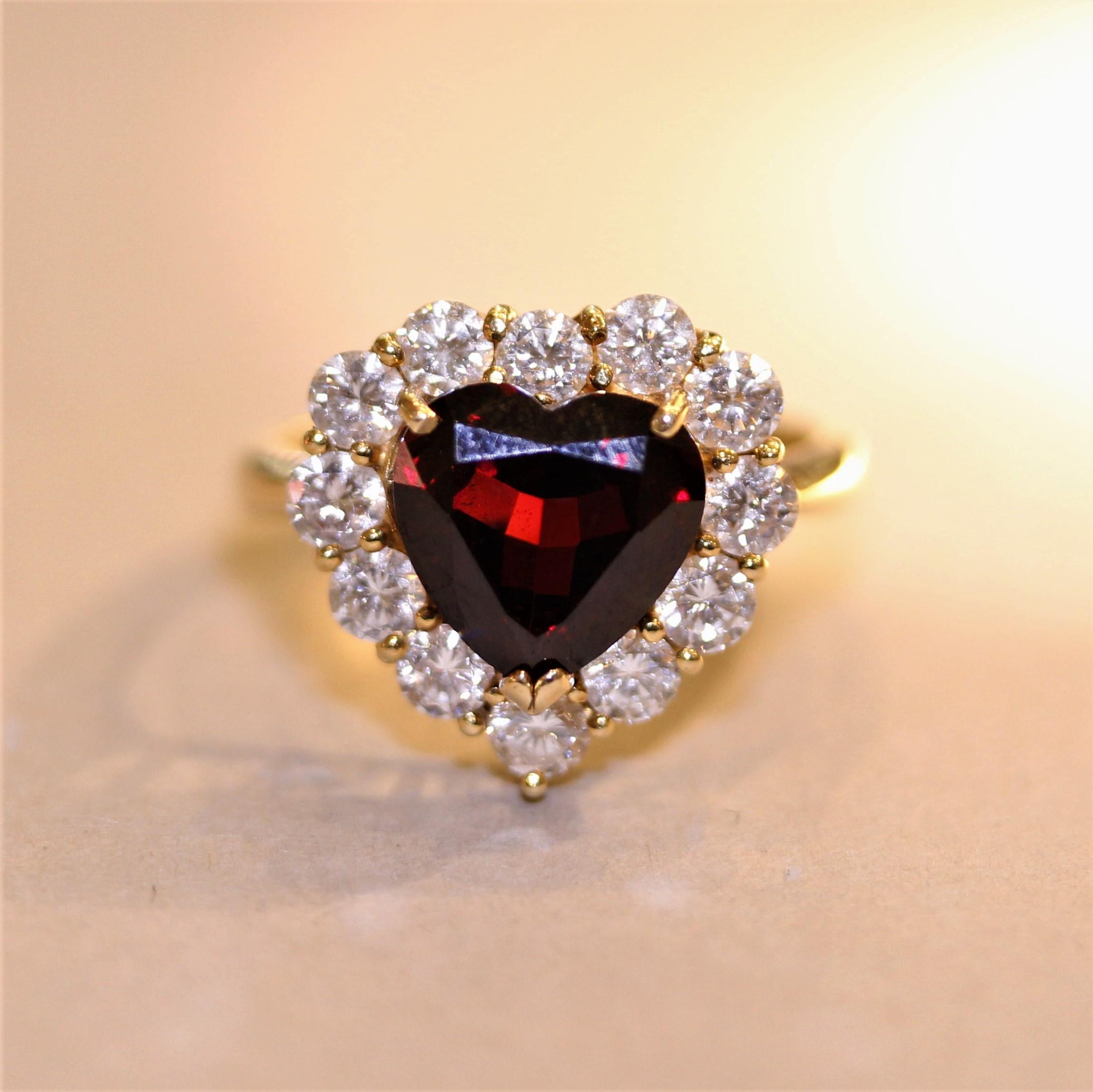 A simple yet stylish garnet ring! It features a fine pyrope garnet shaped as a heart and weighs approximately 3.50 carats. It is accented by a halo of fine round brilliant-cut diamonds which weigh 0.83 carats. Made in 18k yellow gold and ready to be