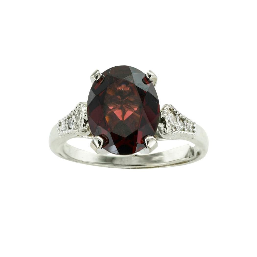 Garnet diamond and platinum solitaire ring.  *

ABOUT THIS ITEM:  #R-DJ1228D. Scroll down for specifications.  The platinum mounting showcases an oval garnet displaying a deep maroon color, flanked by graduating round diamonds to the tapered shank. 
