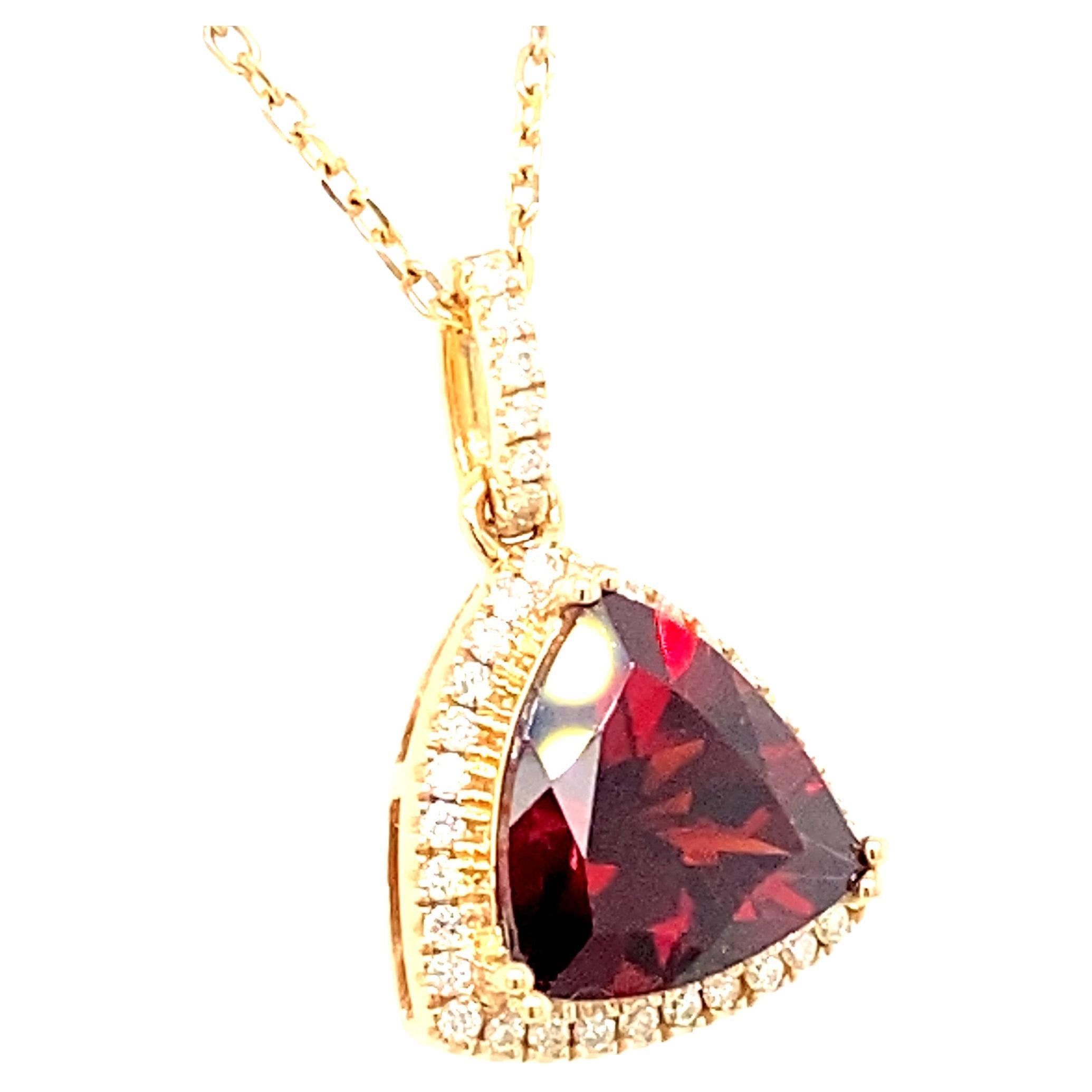 Trillion shape garnet (approximately 6.5ct) is framed by halo of white diamond. Set in 14K yellow gold and has a decorative under-gallery. Birth stone of January, this simple yet elegant pendant is suitable for everyday wear. 
* Chain not included