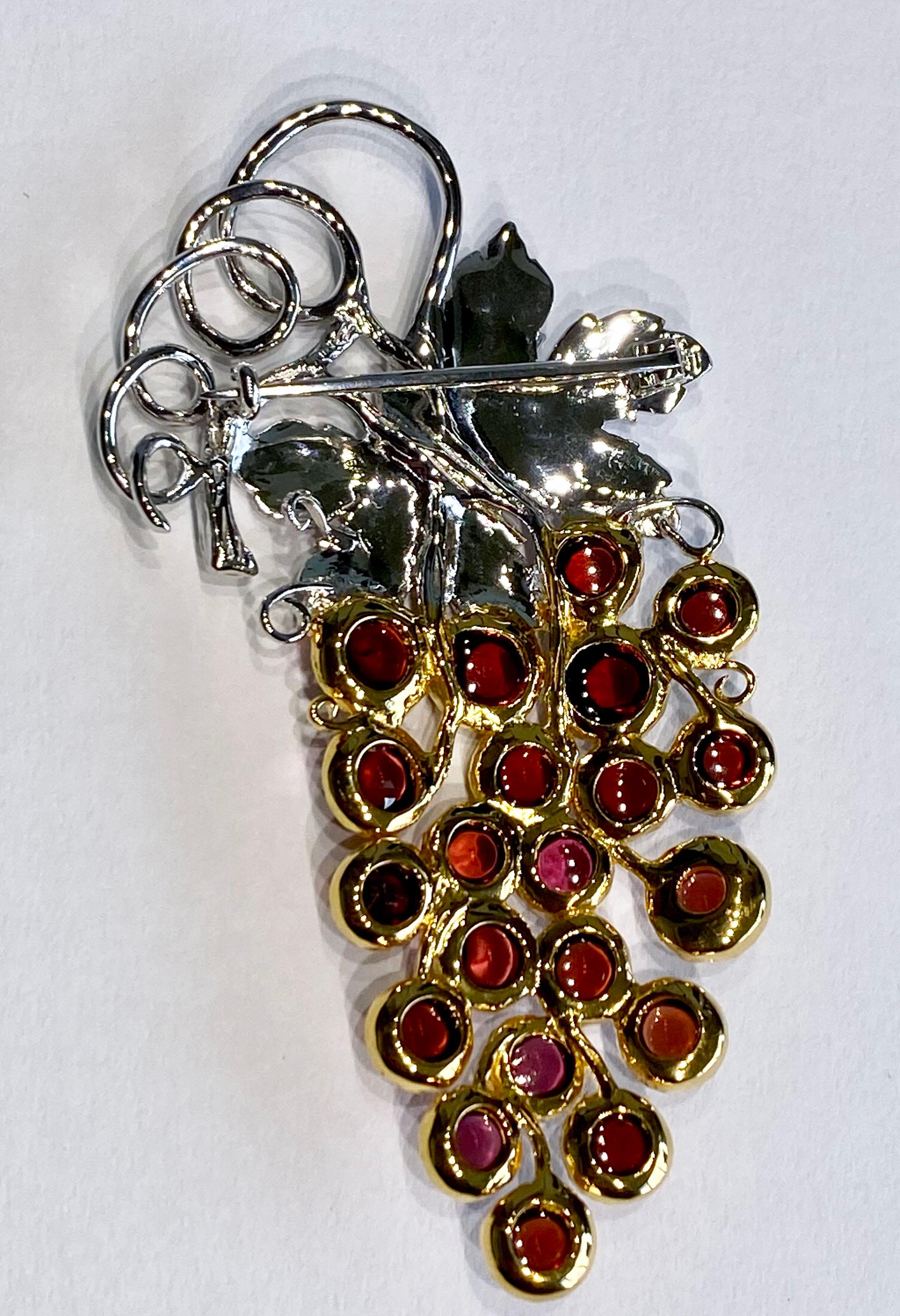 This is a one-of-a-kind masterpiece by Kary Adam. A Garnet Grape Cluster Pin/Brooch set with 21 Pyrope Garnet Cabochons mounted in Gold Plated Silver.

Originally from San Diego, California, Kary Adam lived in the “Gem Capital of the World” -