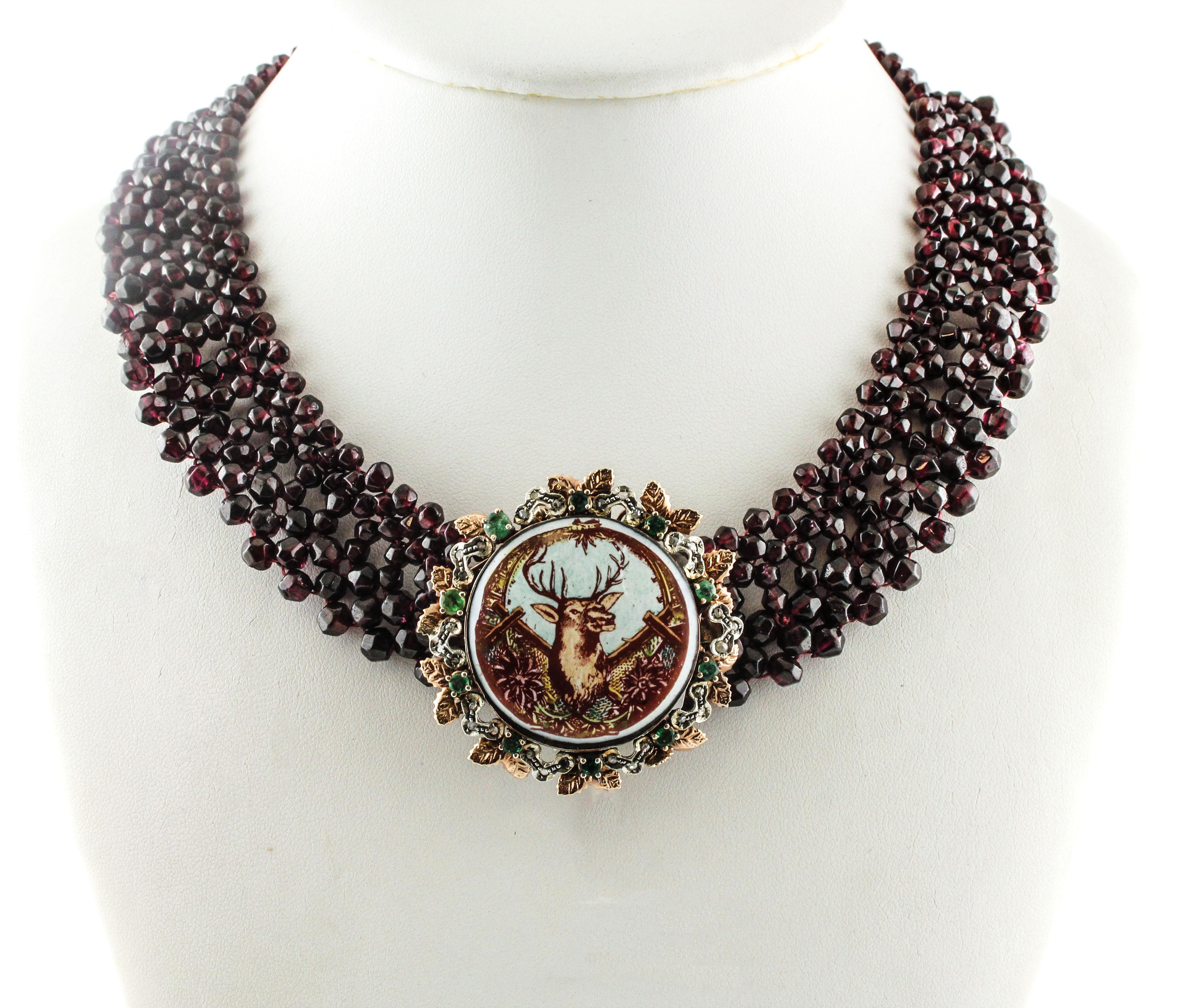 Collier unique en or 9k et argent. Le collier est formé de plusieurs rangs de pierres en grenat et d'une pierre dure centrale peinte d'un motif de cerf. La pierre centrale peinte est également embellie sur tout son pourtour par des détails en or