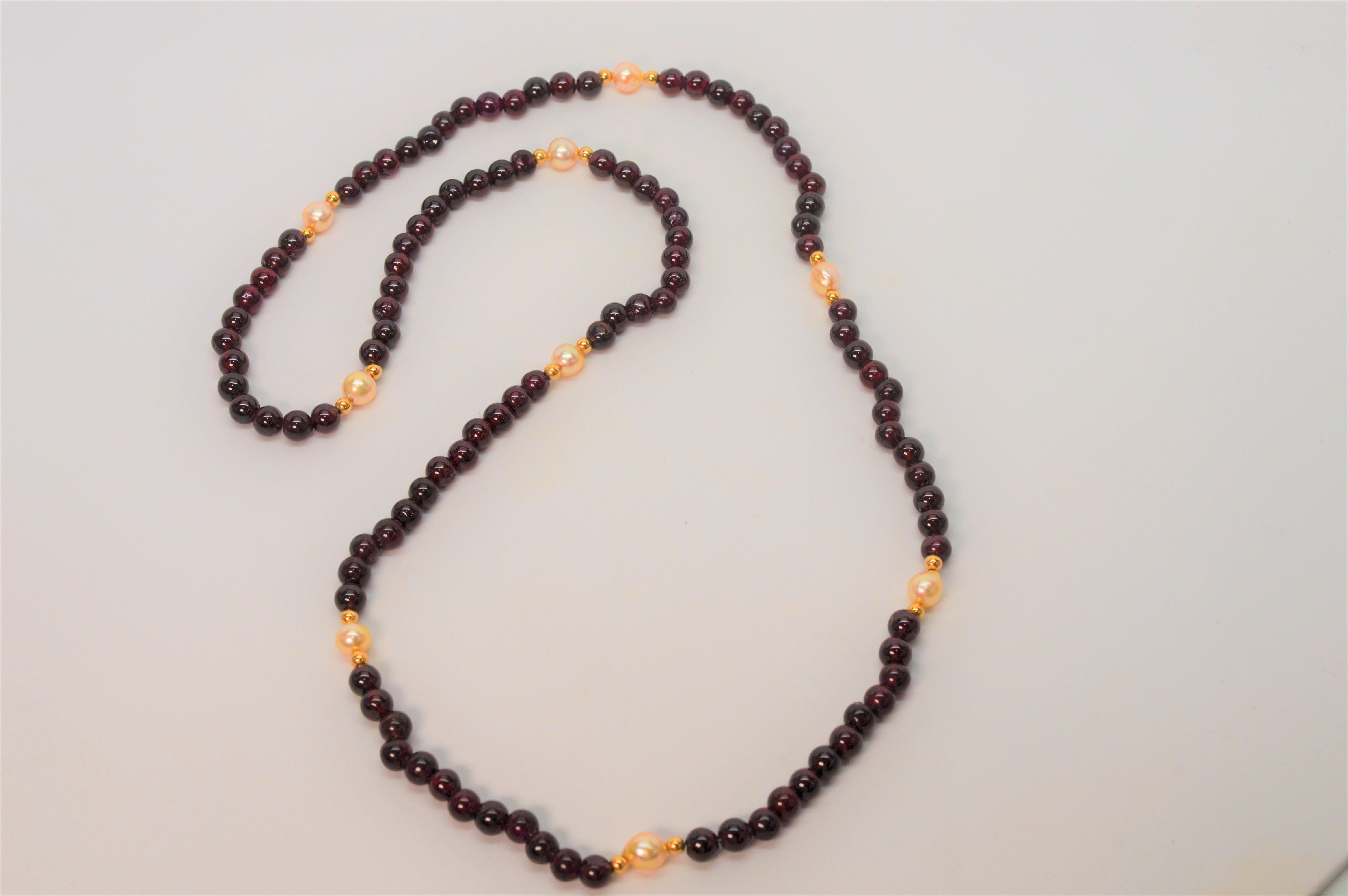 This spiritual stone of higher thinking and strength, these rich dark red garnet beads are strung with complimenting 14 karat yellow gold beads and genuine natural pearls create this colorful piece. The necklace measures 32 inches and is slip-over