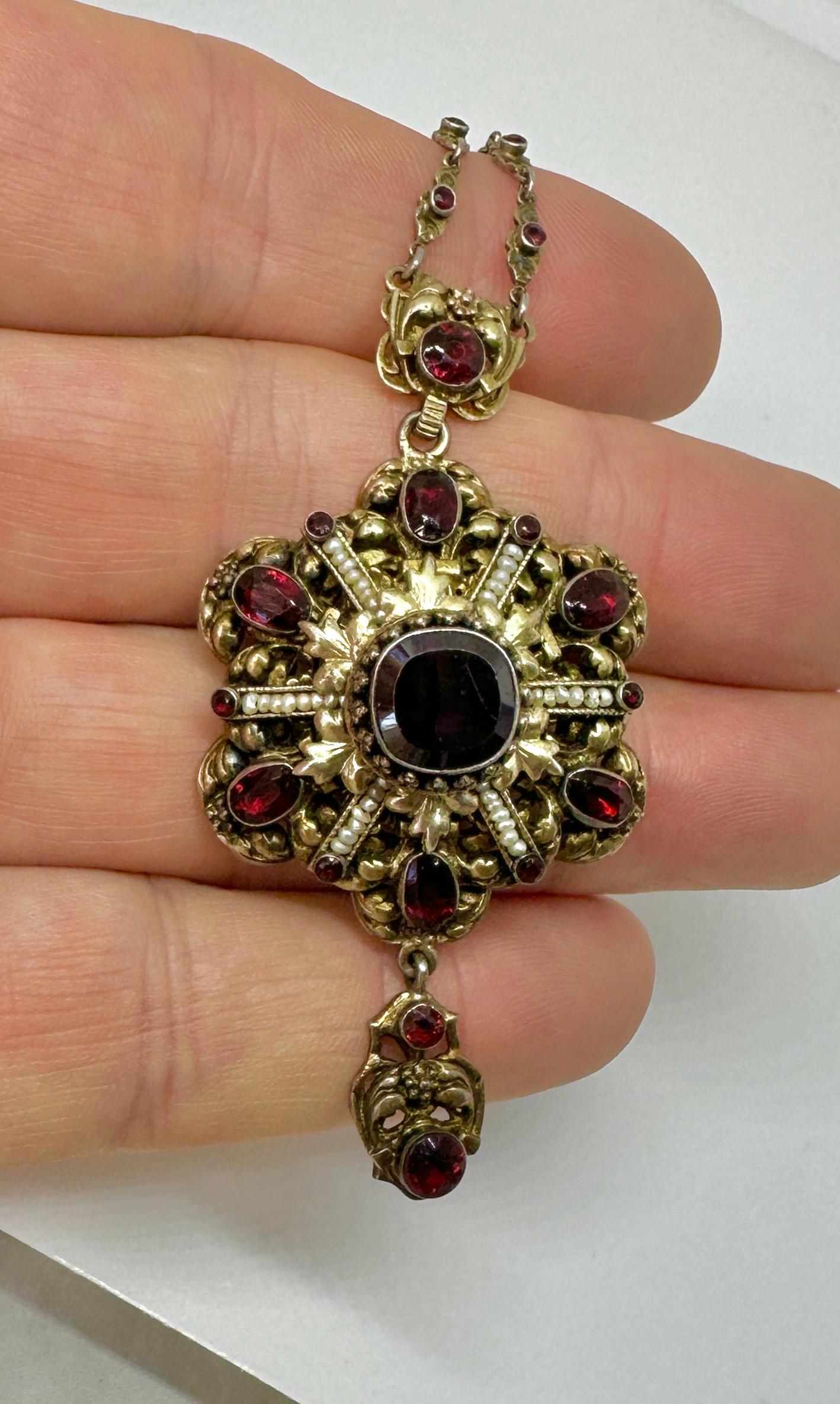 This is a magnificent antique Austro-Hungarian Garnet and Pearl Pendant Necklace with a Garnet set chain in a flower and leaf motif.  It is in the Renaissance Revival style in Silver Gilt and dates to circa 1870.  Recognizable by its bold use of