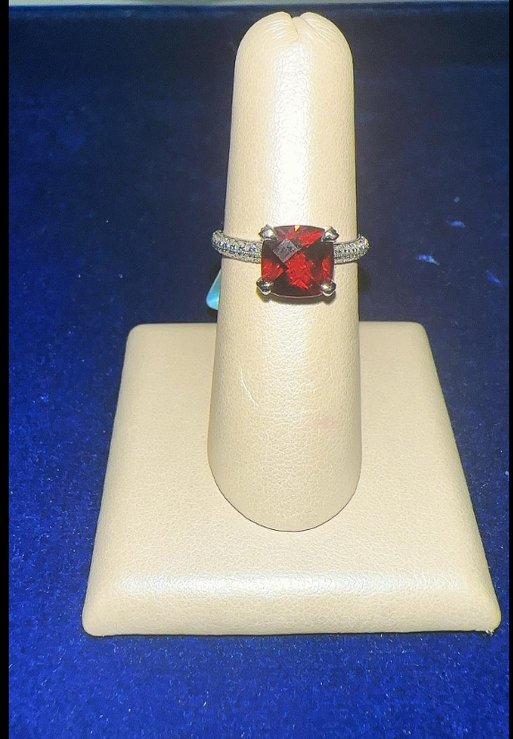 Anello con granato .Questo splendido anello con granato è incastonato in oro bianco 18 carati e presenta al centro un sorprendente granato con taglio a cuscino. La tonalità rosso intenso del granato irradia eleganza, attirando lo sguardo con il suo