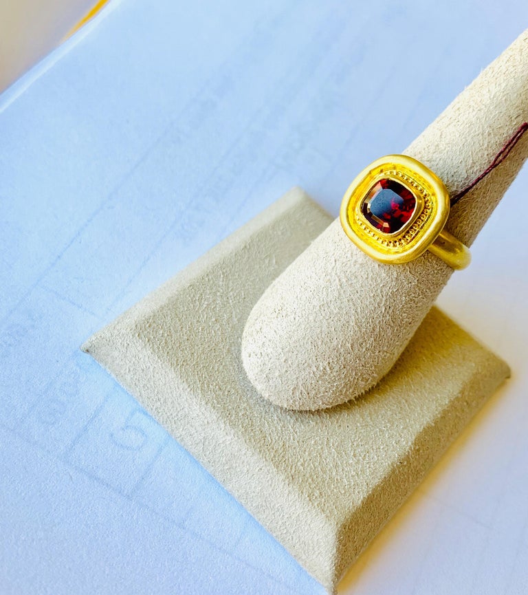 2.5 Ct. garnet square cushion faceted garnet in 22 karat gold with granulation. The ring is size 7.25 and can be resized. Myths suggest the garnet originated with Persephone, Greek goddess of sunshine, and the personification of spring. Entirely