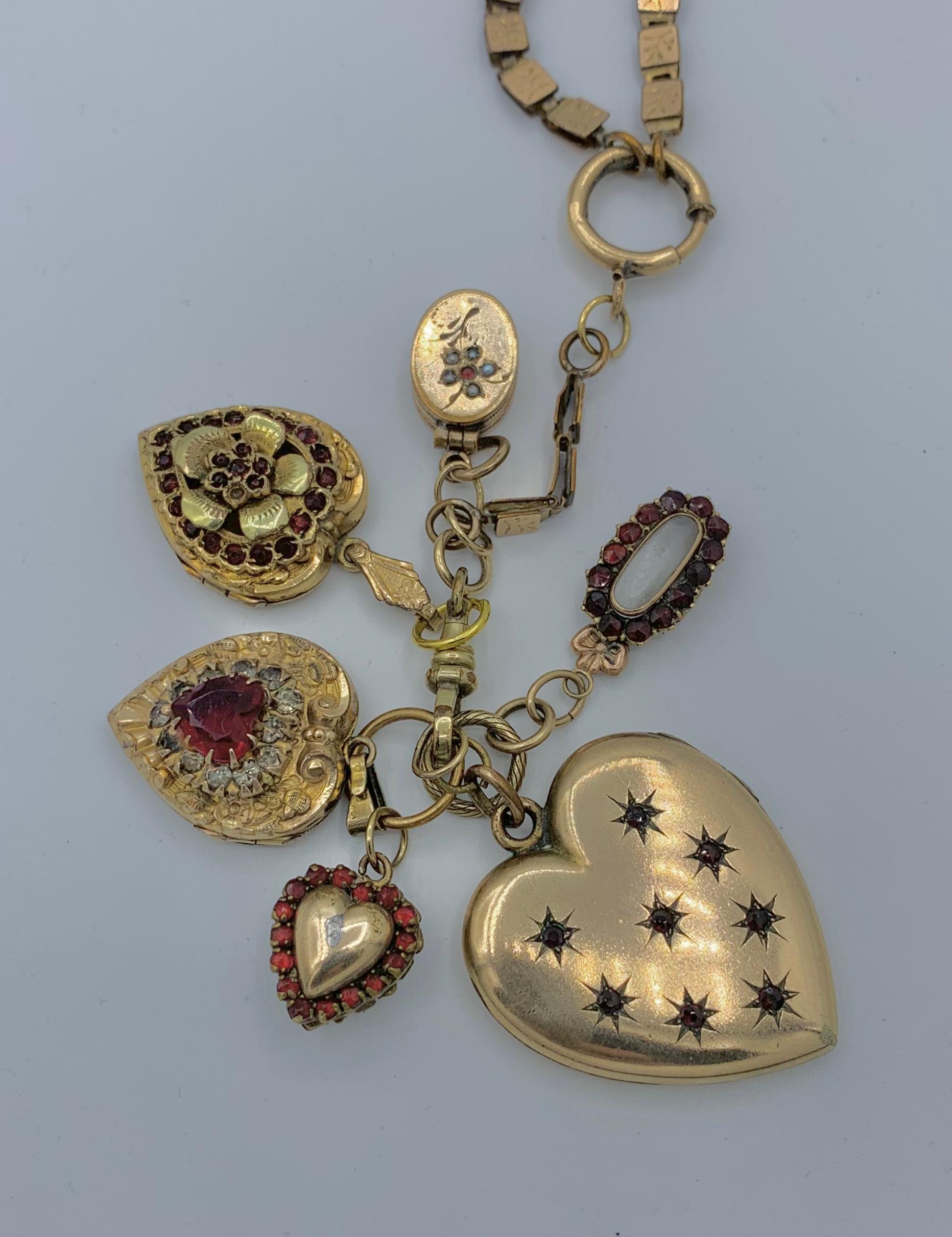 This is just a stunning Victorian Belle Epoque Necklace with 6 antique Picture Locket Charms each set with red Bohemian Garnets in Heart shape and oval motifs.  The lockets and the necklace are gold filled.  The lockets all hang from a large jump