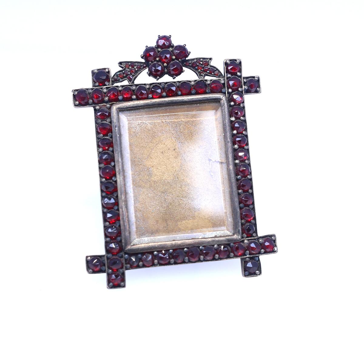 Garnet Picture Frame for the table. 
Former property of  Mary, Duchess of Roxburghe. Sold on the Sotheby’s auction in London:  Property & Precious Objects from the Estate of Mary, Duchess of Roxburghe.
The frame still holds a really fainted