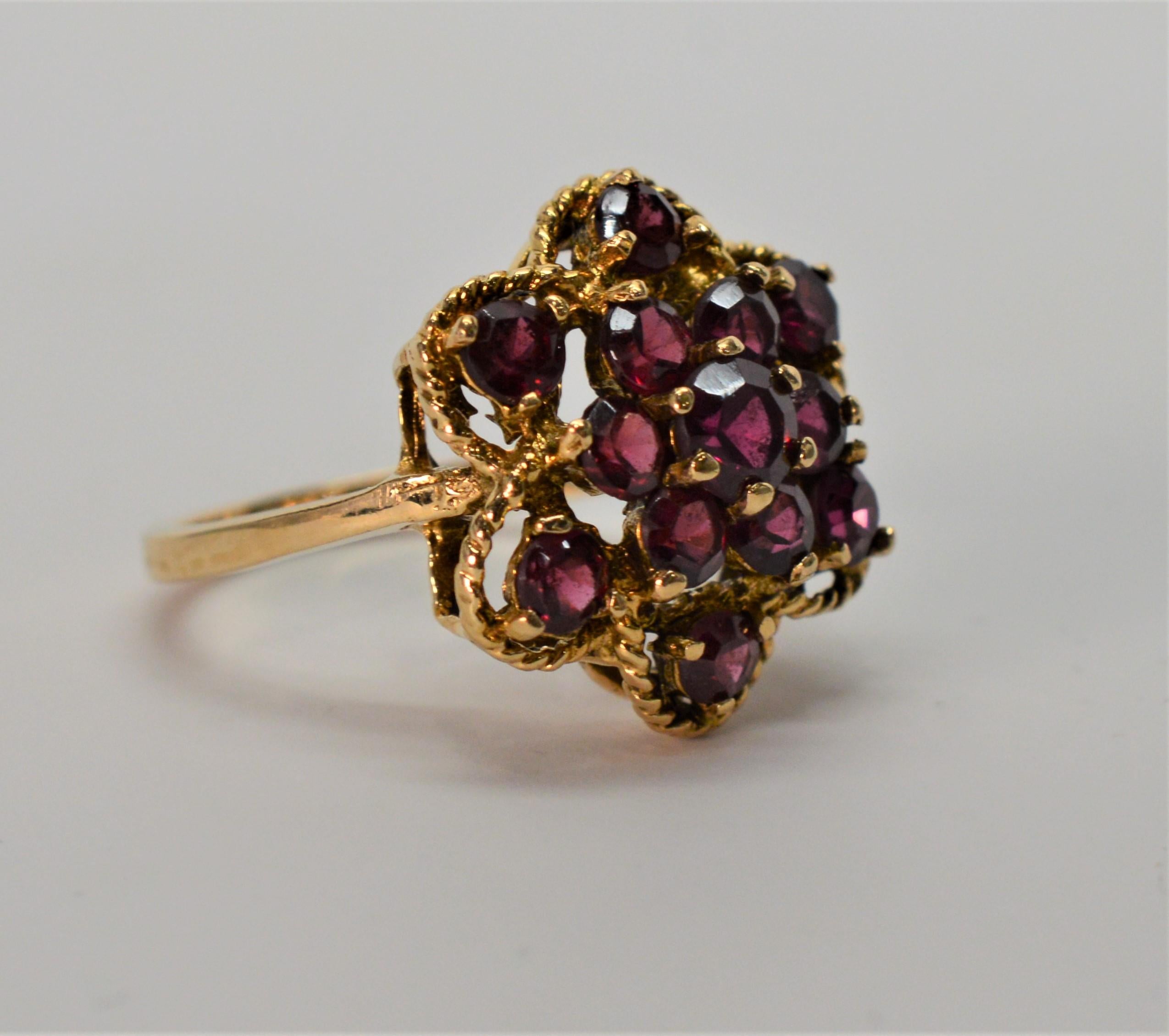 Set in 14 Karat Yellow Gold are thirteen deep rich red Garnet gemstones totaling 1.3 Carats creating this beautiful floral burst cocktail ring. 
In size 6-3/4 , sizable by your jeweler. From the Susan Van Gilder Estate Collection. In gift box.