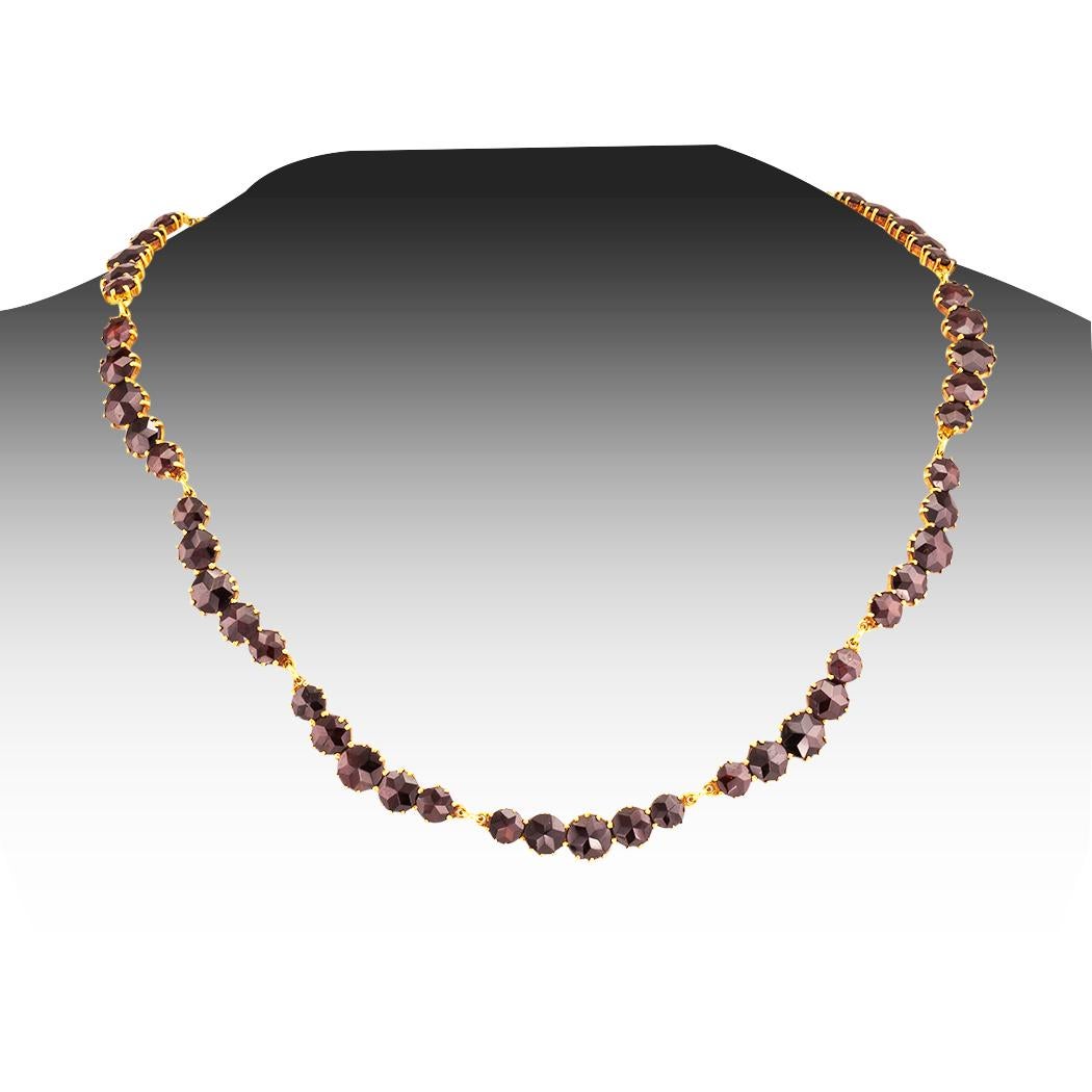  Garnet and gold vintage necklace circa 1970. 

.ABOUT THIS ITEM:  # N-D7228B.  Scroll down for detailed specifications.  The design comprises a series of uniform scalloped courses set with graduating round faceted Bohemian garnets mounted in gold. 