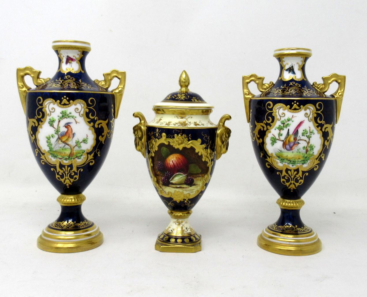 Stylish pair English Porcelain twin handle hand painted Coalport urns, late nineteenth century. 

Exquisitely hand decorated depicting exotic birds, butterflies and flowers in landscape on a cobalt blue ground with lavish raised