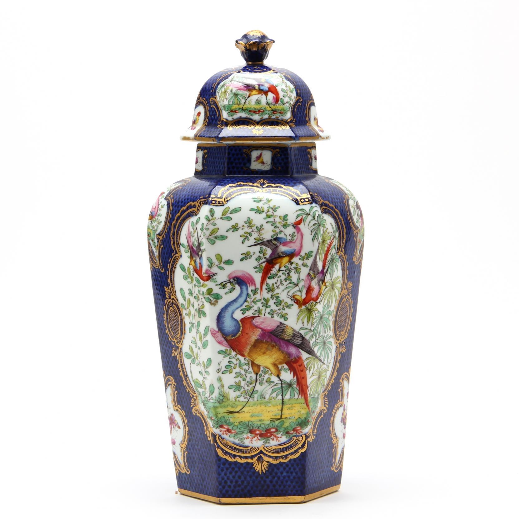 A magnificent English hexagonal porcelain covered jar, in the Worcester porcelain pattern which originated in the 1760’s: scale patterned cobalt blue glazed ground, punctuated by gilt and polychrome decorated cartouches framed in finely gilded