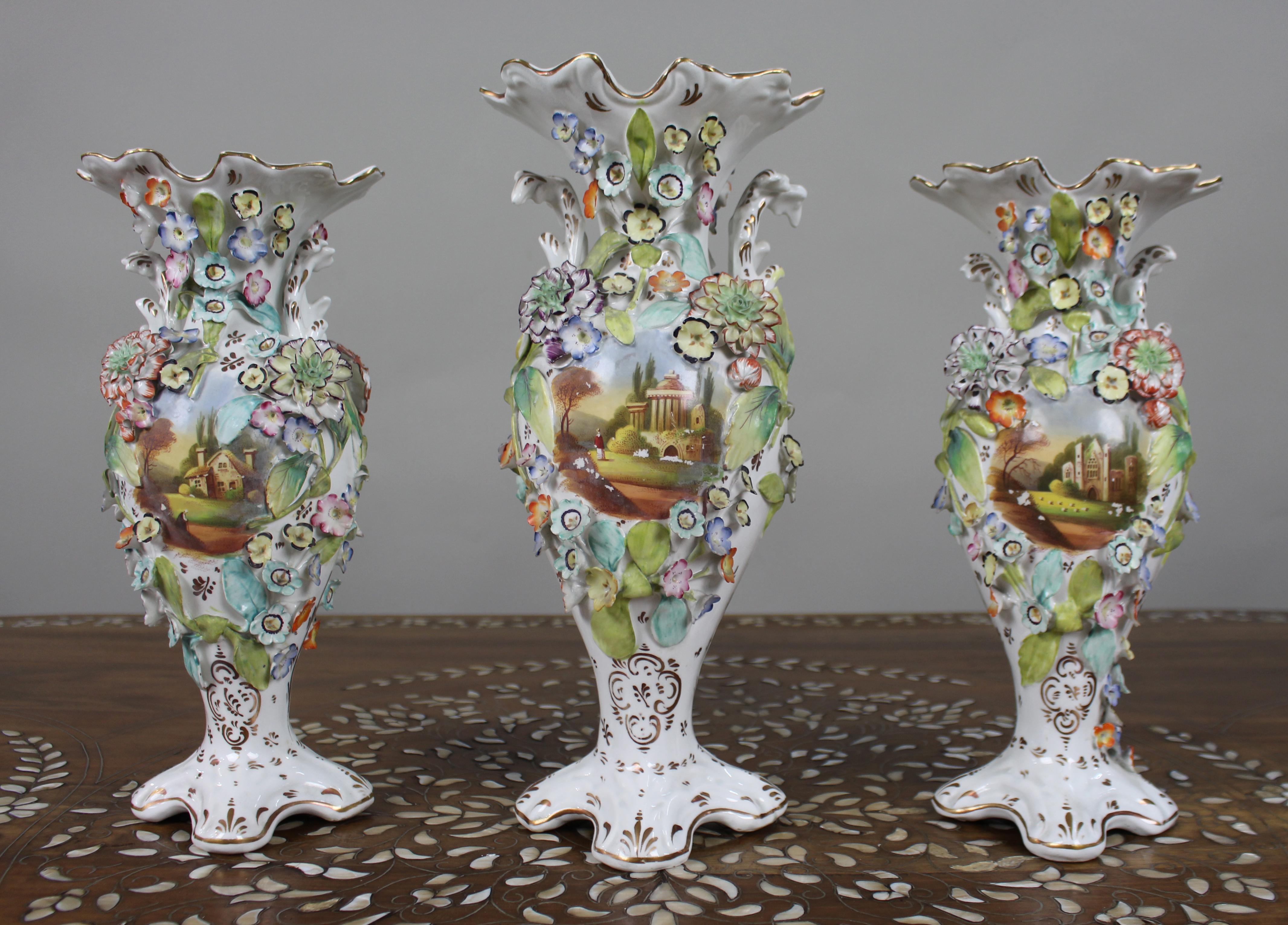 Garniture of Three English Flower-Encrusted Porcelain Vases, c.1850 (probably Samuel Alcock & Co.)

A decorative early-Victorian garniture of three English porcelain vases, unmarked and probably by Samuel Alcock & Co., c.1845–55.
The modelling