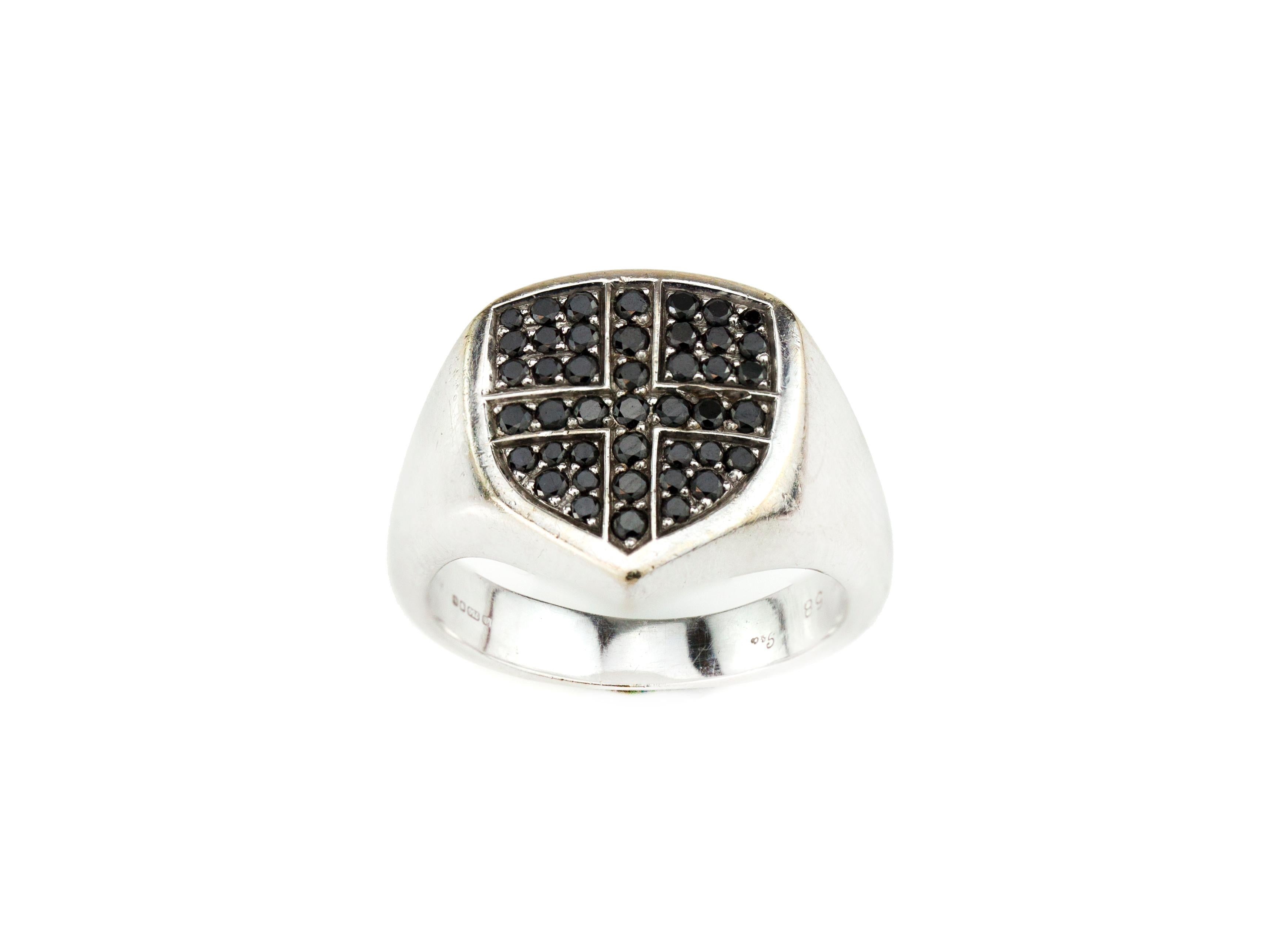 Garrard 18kt white gold men's ring with black diamonds. Ring crest is shaped like a shield and set with black diamonds. Ring has an engraving on behind 