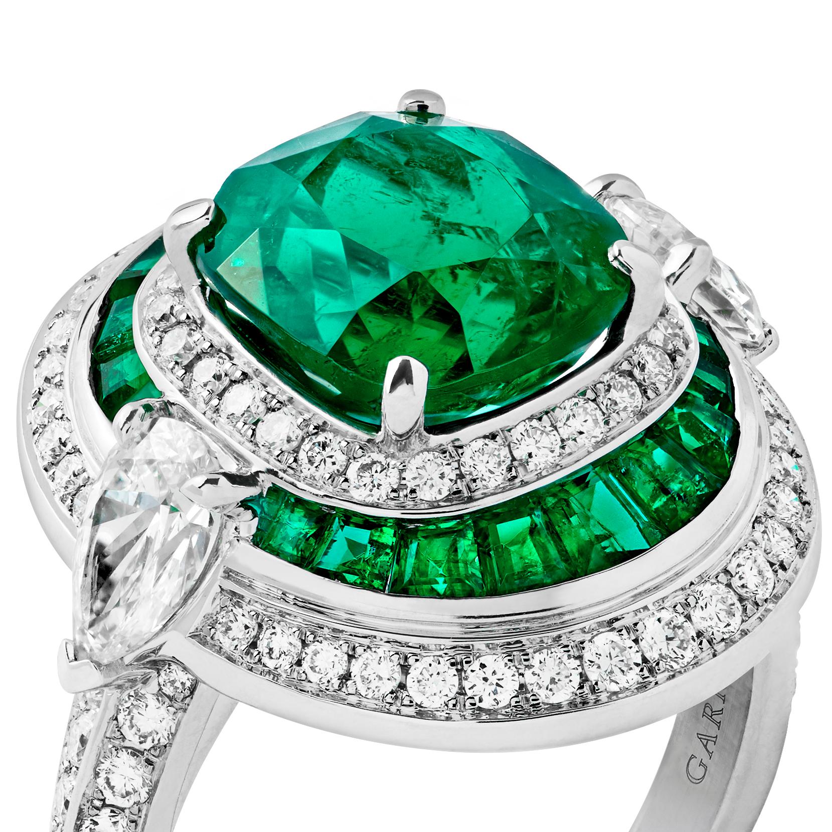 A House of Garrard 18 karat white gold ring from the Jewelled Vault collection, set with a central CDC certified cushion cut 3.08 carat emerald, 18 calibre cut emeralds weighing 1.44 carats, 96 round white diamonds weighing 0.64 carats and 2 pear