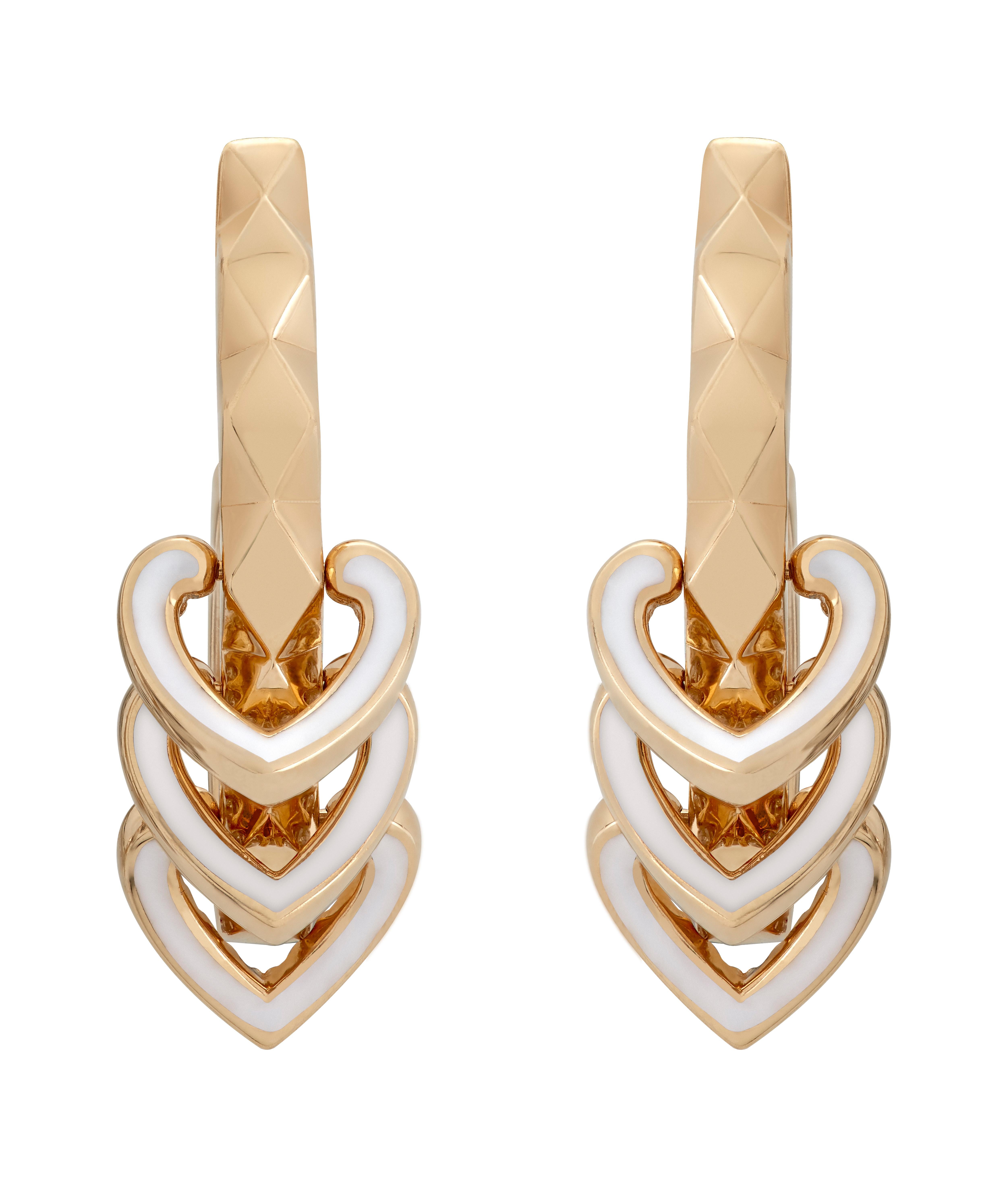 A House of Garrard pair of 18 karat yellow gold earrings from the 'Aloria' collection, patterned with faceted gold and each centred with 3 reversable round white diamond and white enamel motifs. 

78 round white diamonds weighing: 0.79cts

The House