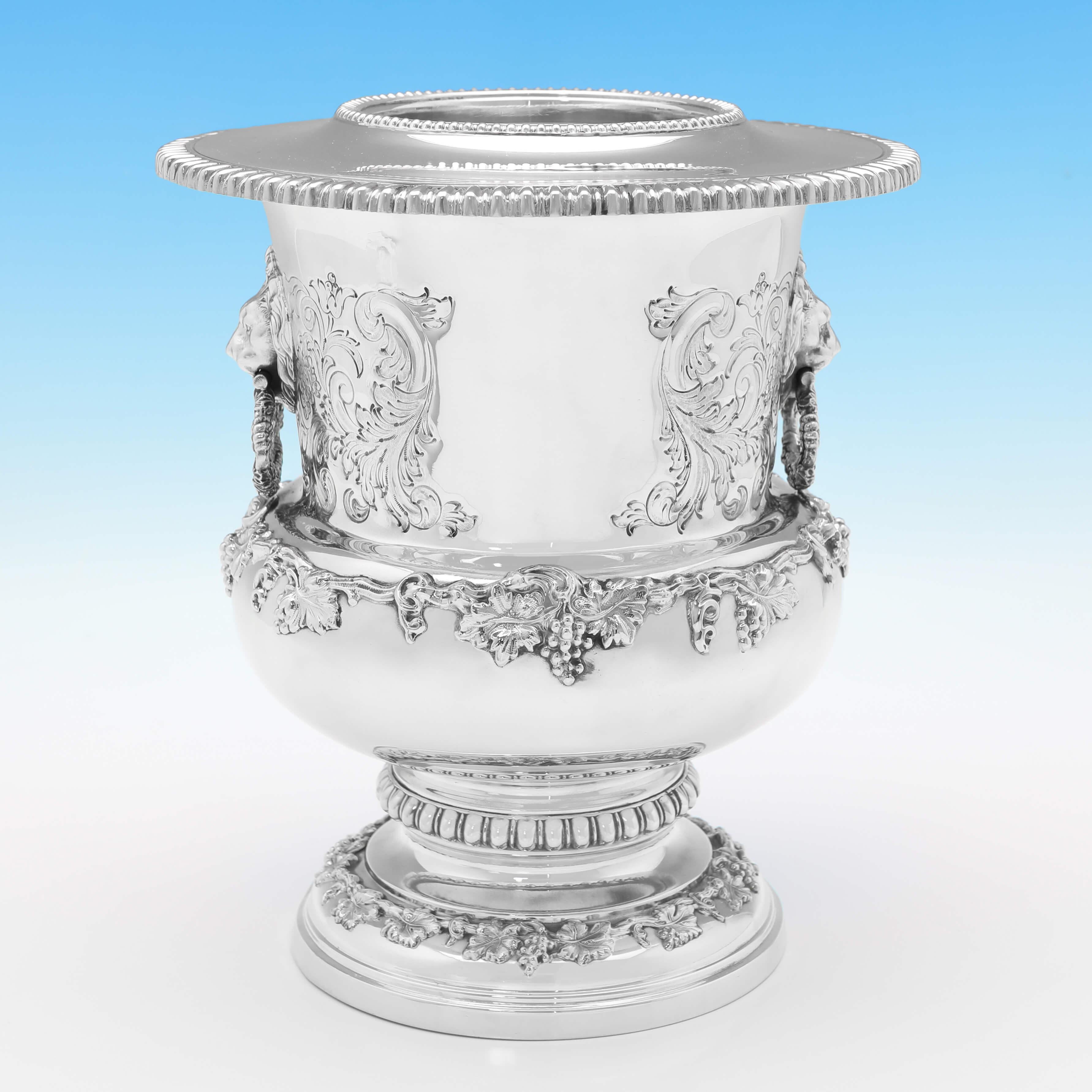 Hallmarked in London in 1973 by Garrard & Co., this striking pair of Sterling Silver Wine Coolers, are in the campagna shape, and feature chased acanthus decoration, lion mask drop ring handle, cast and applied grape and vine borders, and removable
