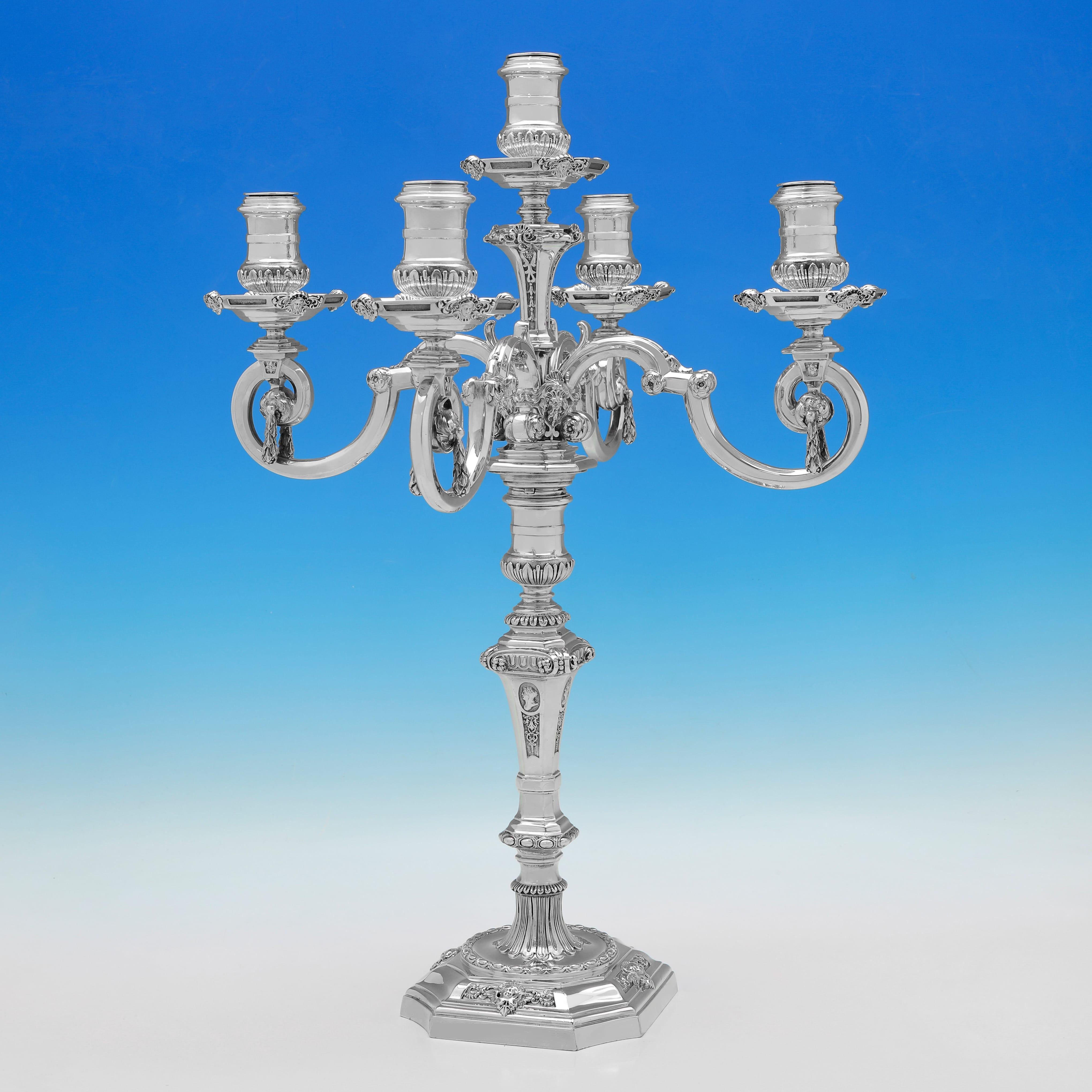 Poinçonnée à Londres en 1889 et 1893 par R & S Garrard & Co, cette belle et grande paire de chandeliers anciens en argent massif est coulée, peut contenir 5 bougies chacun et est de style George II. 

Chaque candélabre mesure 22,5