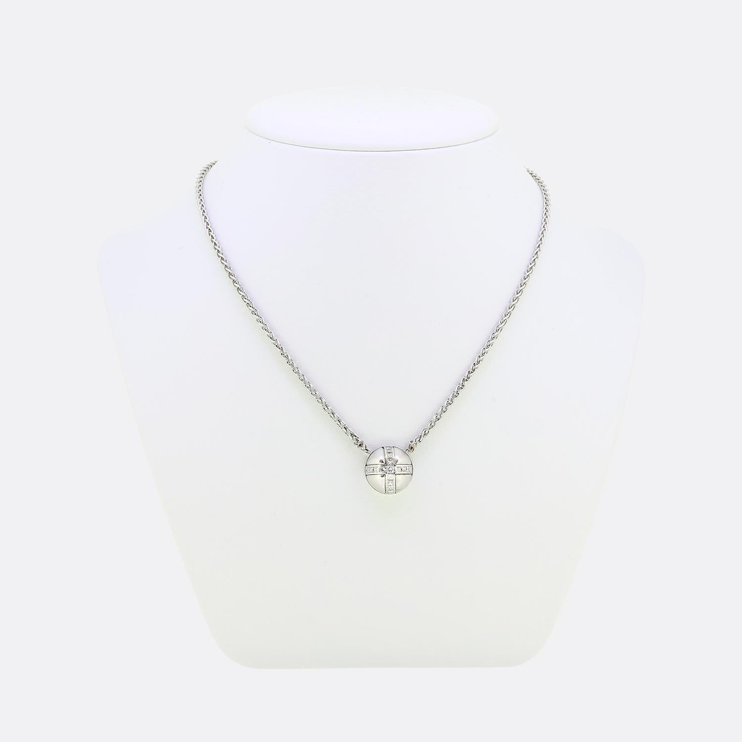 This is an 18ct white gold pendant necklace from the designer Garrard. The chain is in a wheat style and features a domed pendant set with 17 princess cut diamonds in a cross shape. Since 1735 Garrard has been creating fine pieces of jewellery