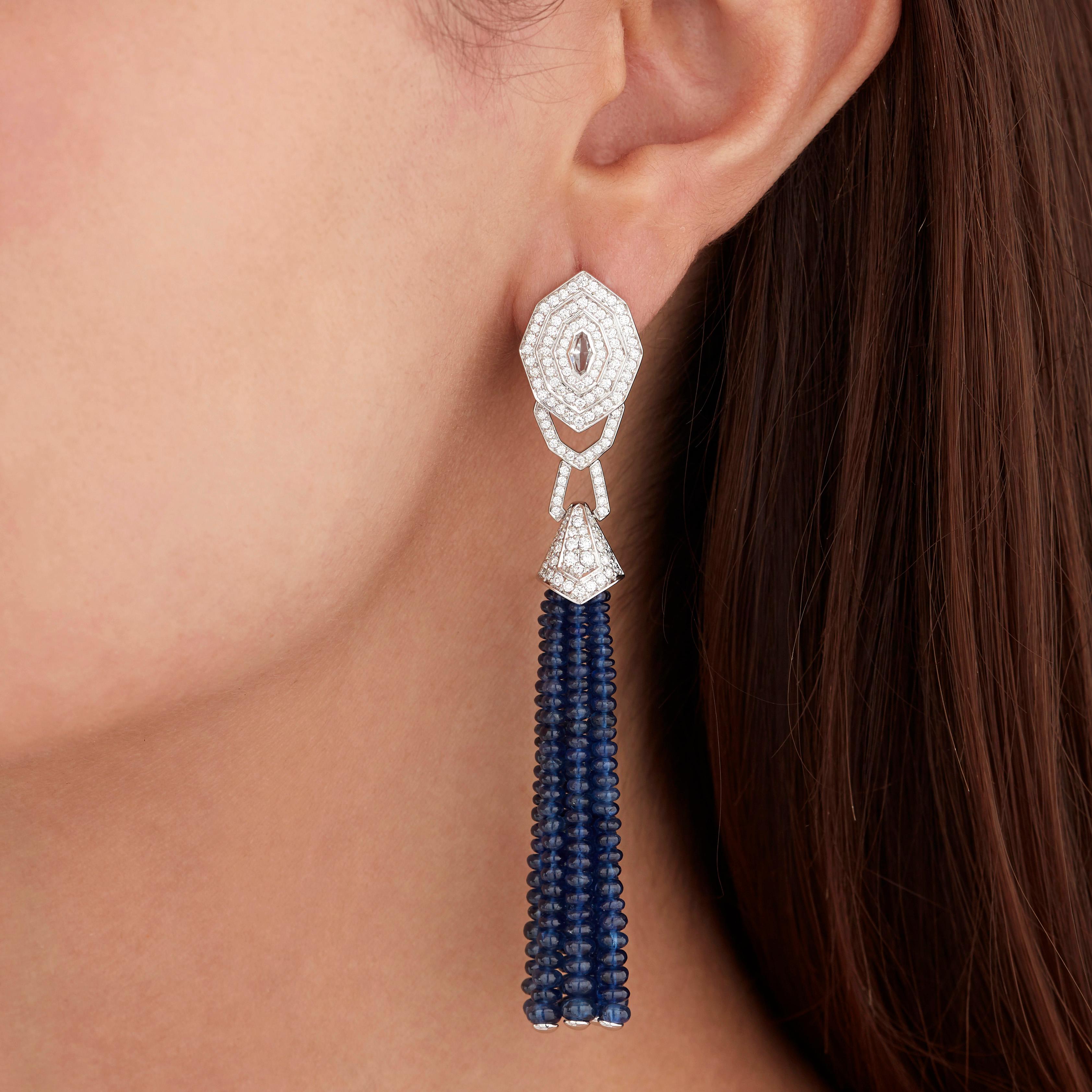 A House of Garrard pair of 18 karat white gold earrings from the Enchanted Palace collection set with rock crystal, round white diamonds and polished sapphire bead tassels.

2 pieces of rock crystal weighing: 0.19cts
14 strands of polished sapphire