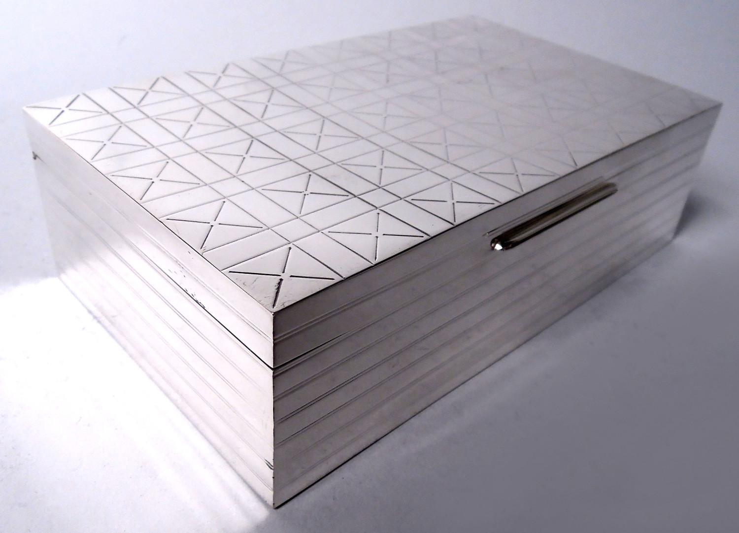 Caja de plata de ley de Jorge VI. Fabricado por Garrard & Co. en Londres en 1947. Rectangular con lados rectos. Cubierta plana, con lengüetas y bisagras. Los laterales tienen bandas envolventes con lengüeta. La parte superior de la tapa tiene una