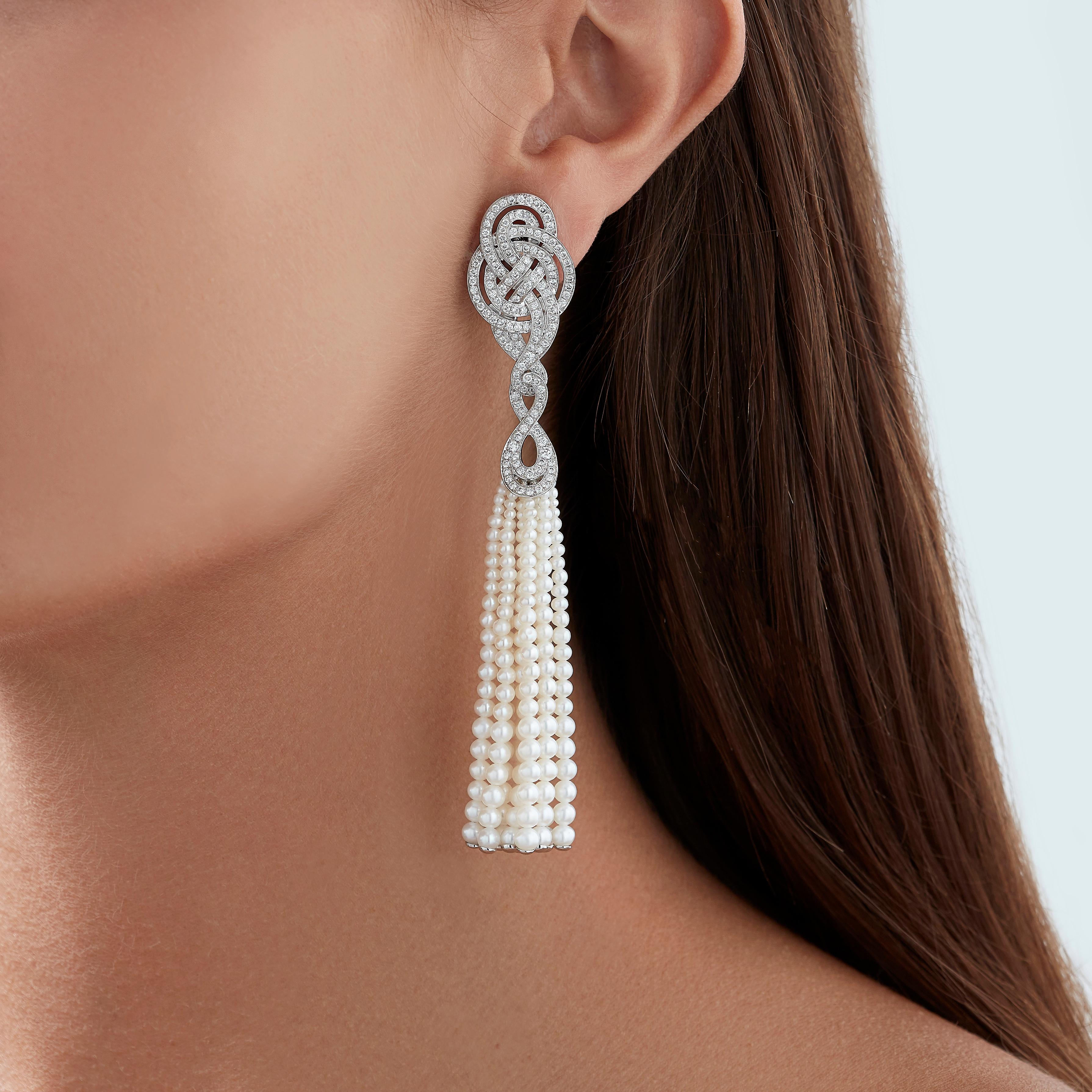 A House of Garrard pair of 18 karat white gold earrings from the 'Entanglement' collection, set with round white diamonds and white pearls.

284 round white diamonds weighing: 1.99cts
18 strands of white pearls                                       