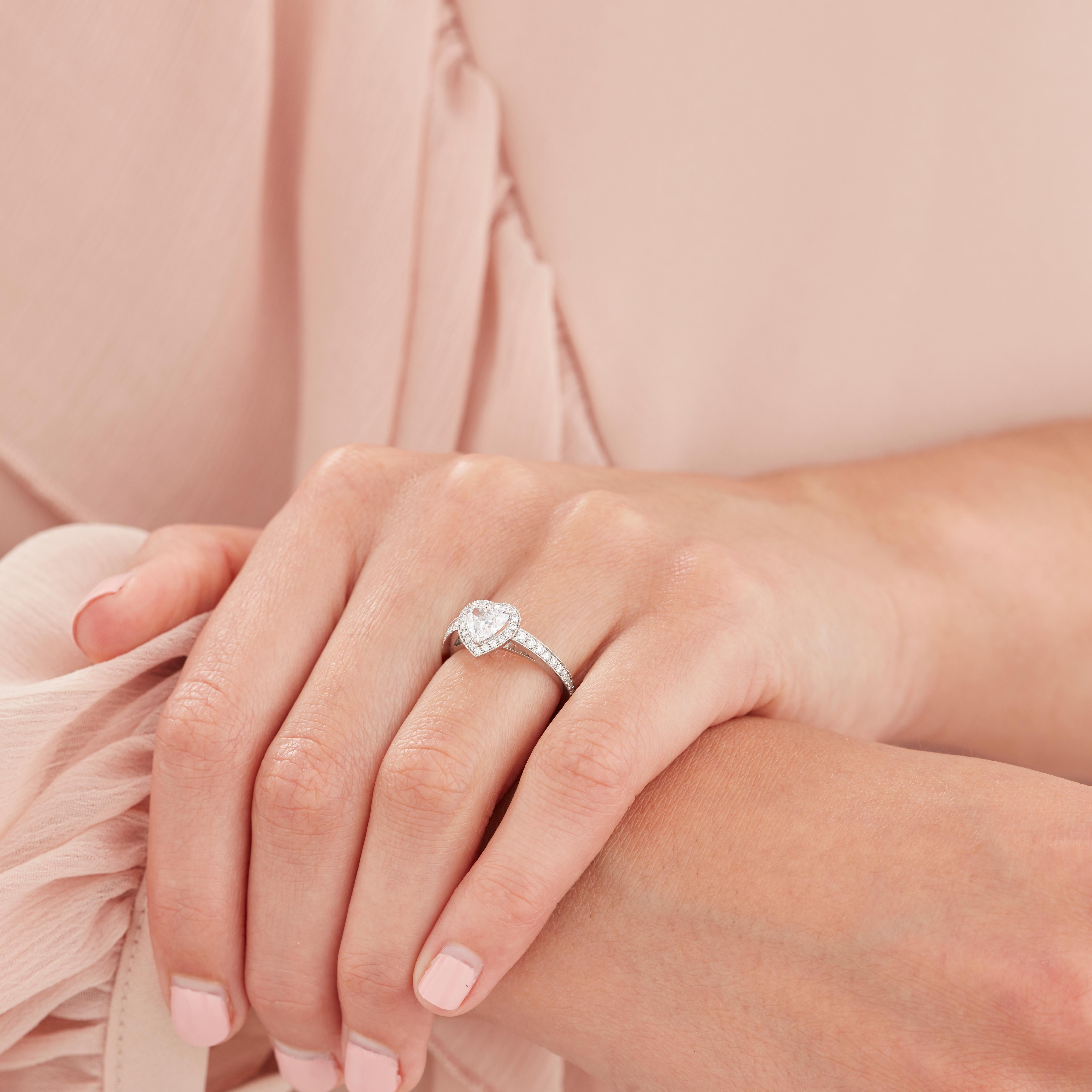 A House of Garrard platinum 'Evermore' ring set with a central heart shape white diamond and round white diamonds.                                                                                               1 heart shape diamond weighing 0.81cts D