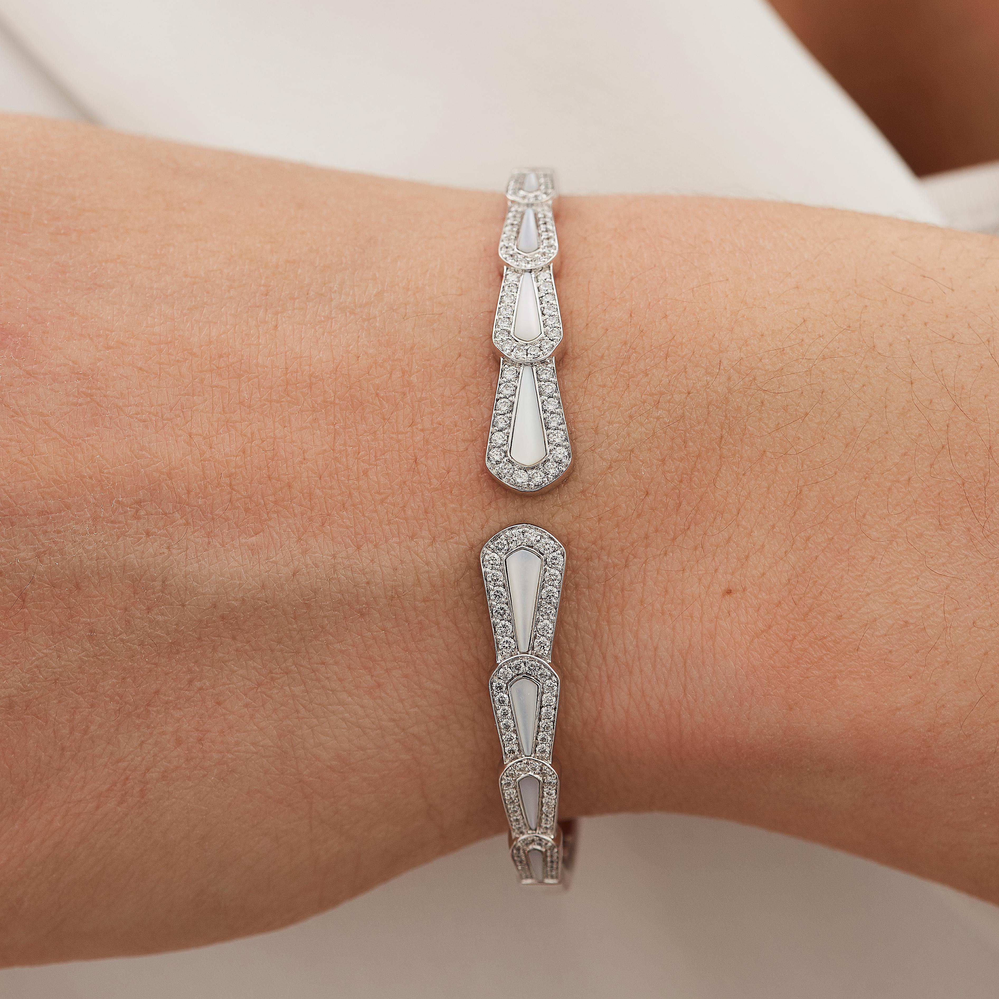 A House of Garrard 18 karat white gold bangle from the 'Fanfare' collection, set with round white diamonds and mother of pearls.

8 mother of pearl weighing: 1.12cts
123 round white diamonds weighing: 0.87cts

The House of Garrard is the longest