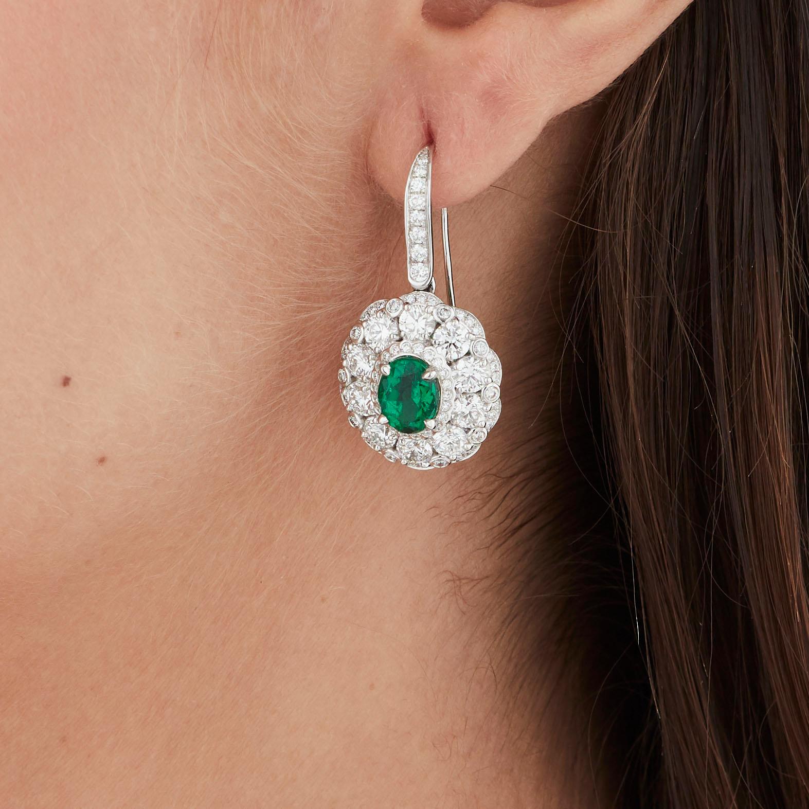 A House of Garrard 18 karat white gold 'Jewelled Vault' earrings with central oval emeralds set in a round white diamond surround and mount.

1 oval emerald weighing: 1.97cts 
1 oval emerald weighing: 1.88cts
Both Gubelin certified: Colombia, minor