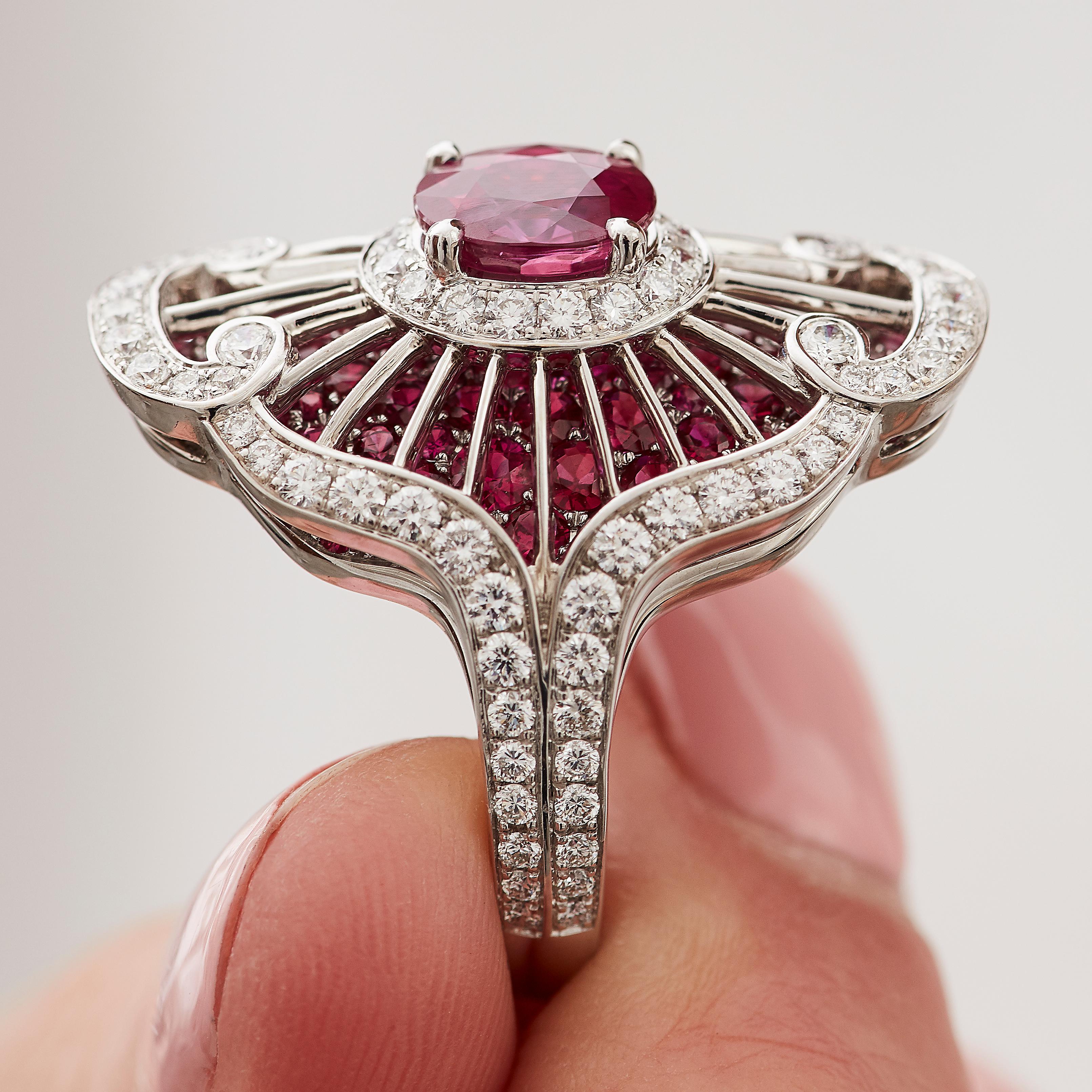 A House of Garrard 18 karat white gold 'Jewelled Vault' ring set with a central GIA certified oval ruby, with radiating knife-bars and round white diamonds set raised above a round ruby pavé base.

1 Oval ruby weighing: 1.70cts                      