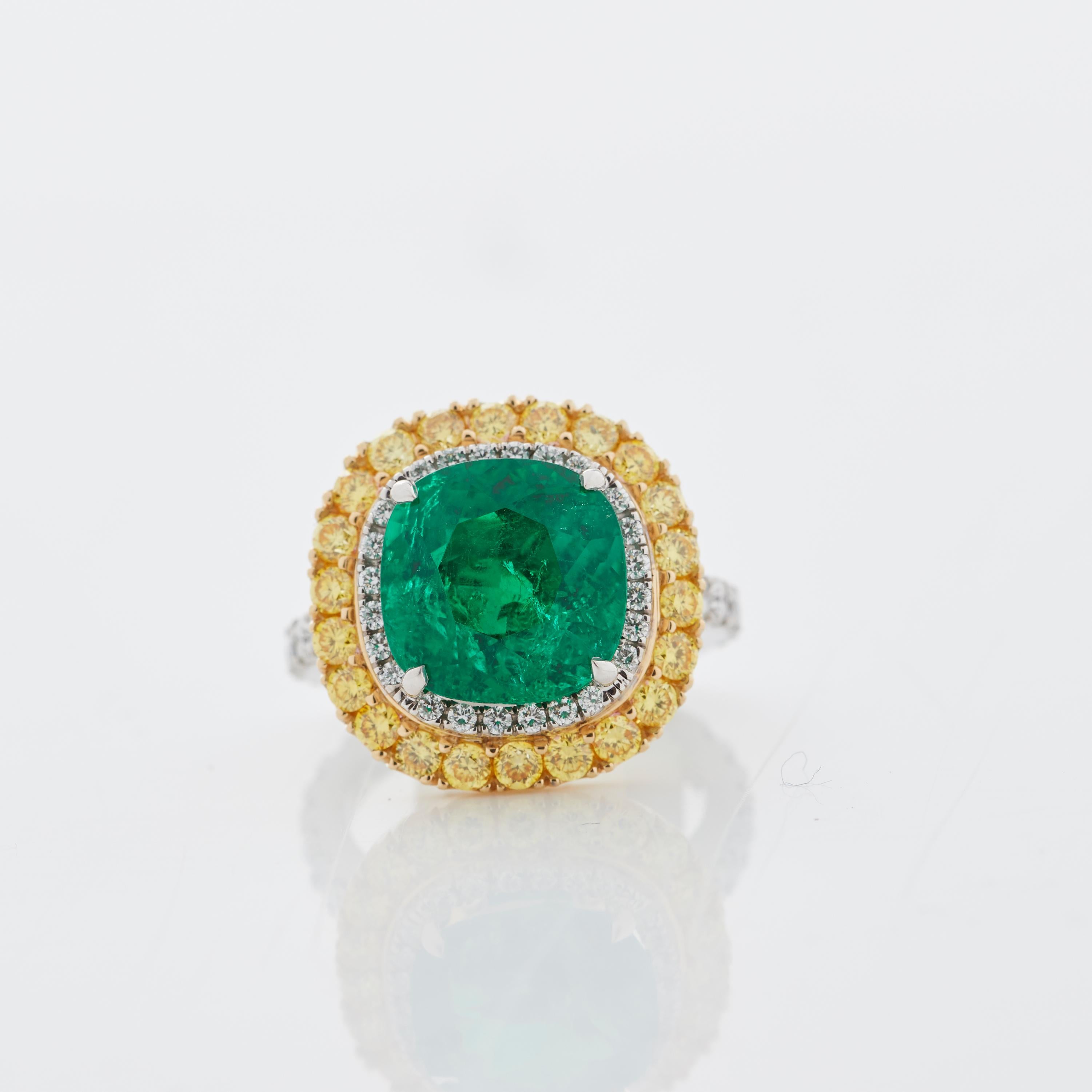 A House of Garrard 18 karat white gold 'Jewelled Vault' ring, set with round white diamonds, round yellow diamonds and a central cushion cut emerald. 

1 cushion cut emerald weighing: 6.70cts 
38 round white diamonds weighing: 0.90cts               