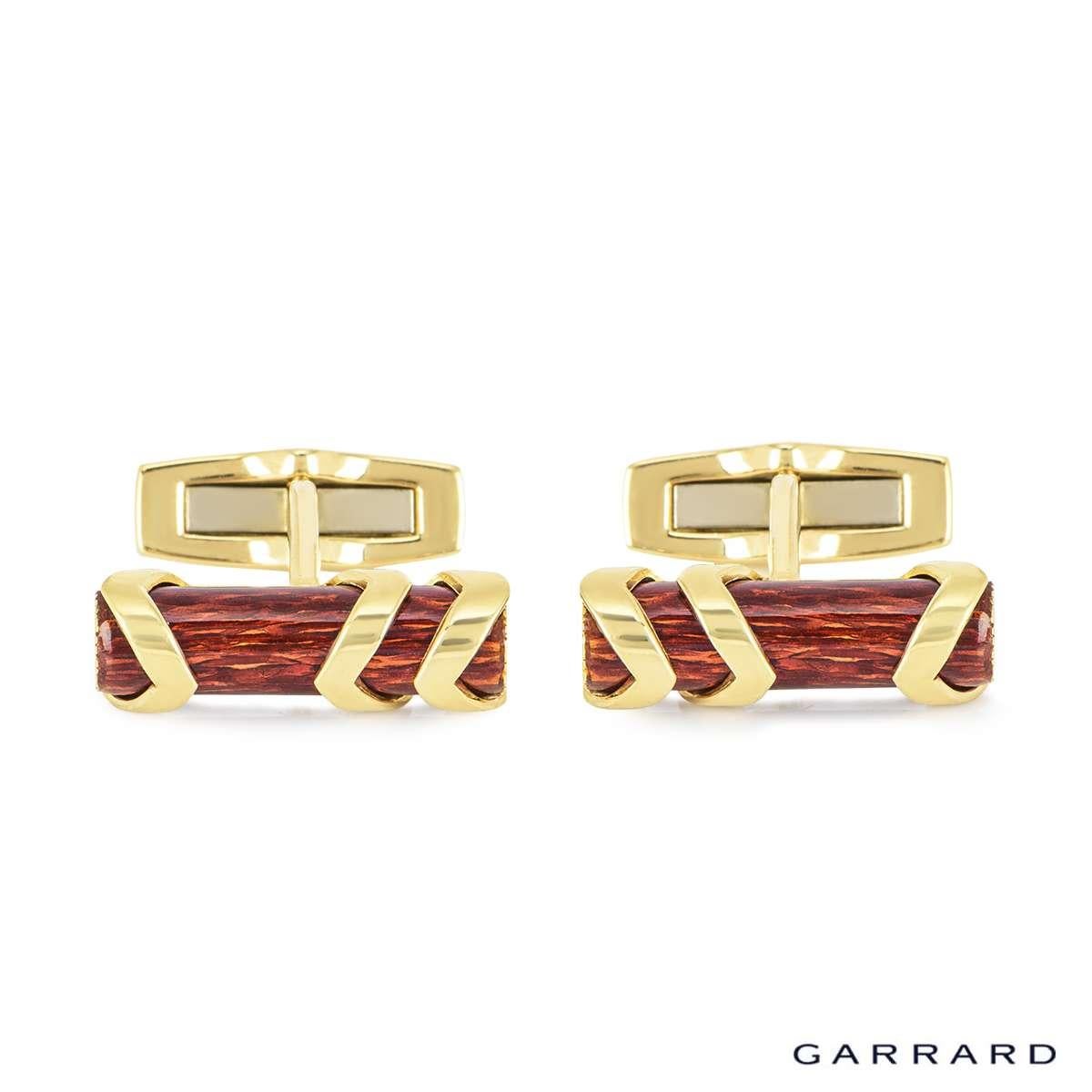 A pair of 18k yellow gold enamel log cufflinks by Garrard. The cufflinks are each set with a mahogany enamel log motif centre with a bark design finish and are encased by three supporting shaped panels and are finished with a classic hinged T bar