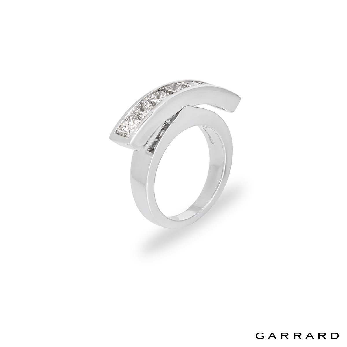 A unique diamond dress ring in platinum by Garrard. The ring features a diamond set bar with a seesaw mechanism allowing the bar to move from side to side. The bar is set with 7 princess cut diamonds with an approximate weight of 1.40ct. The ring is