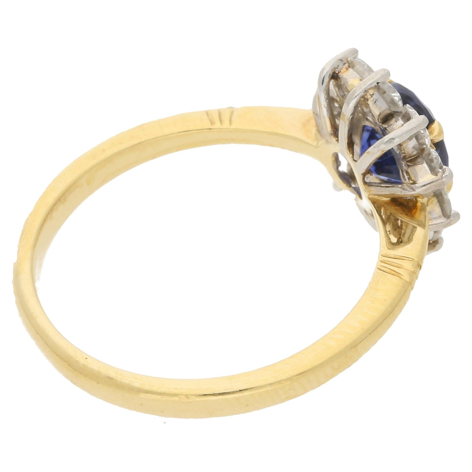 18k mixed gold sapphire and diamond cluster ring, signed Garrard & Co. The ring features a deep blue oval sapphire with 0.89 carats on a yellow gold claw open-back setting, surrounded by a halo of 10 round brilliant-cut diamonds with a combined