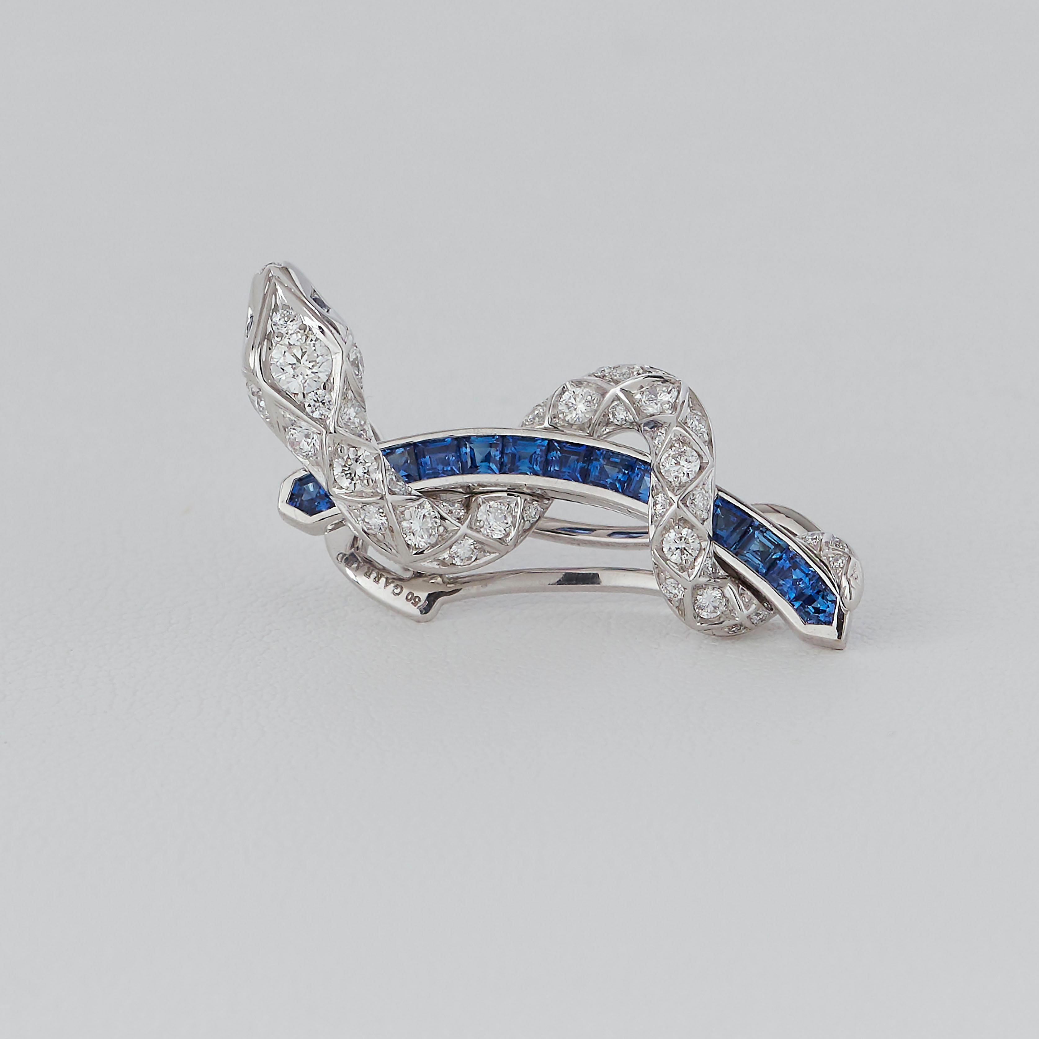 A House of Garrard pair of 18 karat white gold 'Signature Serpent' ear-climbers from the 'Muse' collection, set with round white diamonds and round and calibre-cut blue sapphires.

4 blue sapphire eyes weighing .03ct
24 blue sapphires weighing