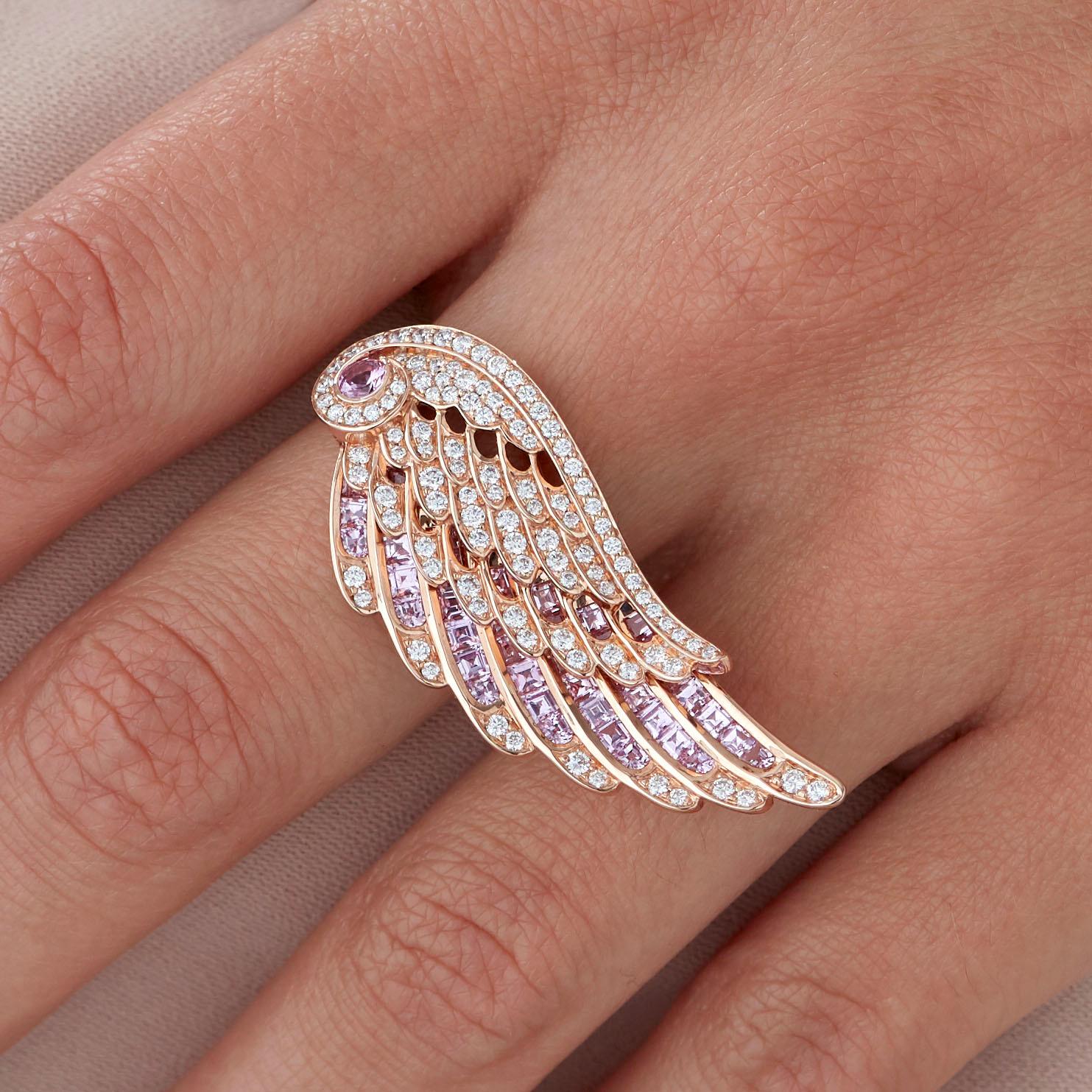 A House of Garrard 18 karat rose gold ring from the 'Wings Embrace' collection with a cross- finger double wing motif, set with round white diamonds and round and calibre cut pink sapphires.

106 round white diamonds weighing: 0.78cts 
1 round pink
