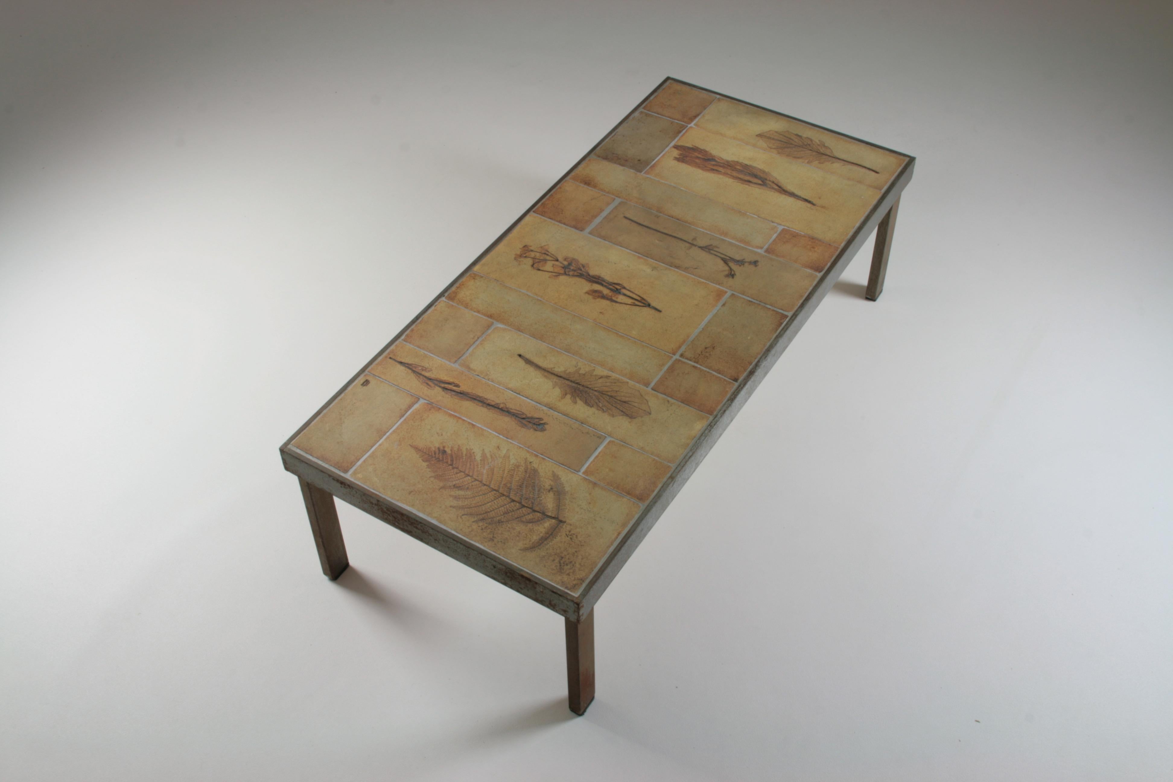 Garrigue rectangular coffee table by roger capron in vallauris, france and dating from the 1960s. Metal structure and legs with a ceramic top with inlaid herbarium motifs. All ceramics are in good condition and the metal is patinated as seen in all