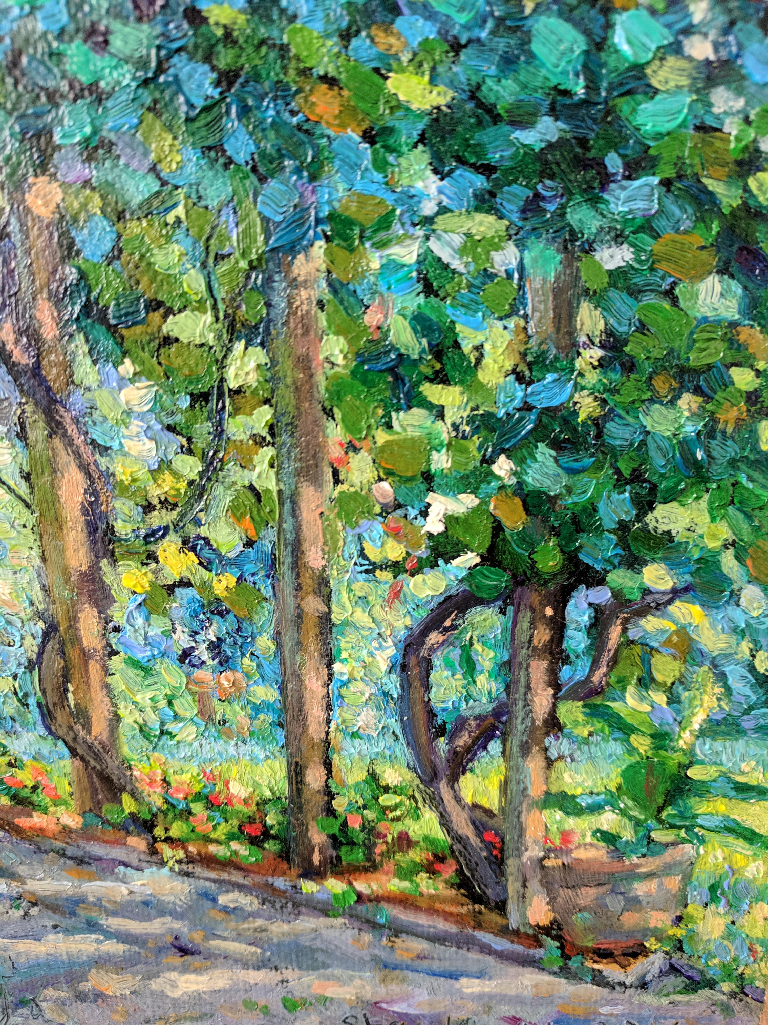Cette peinture à l'huile sur lin est un bel exemple de paysage impressionniste américain réalisé par un peintre magistral. Le tableau présente une scène d'arbres verts et multicolores qui embrassent un chemin de pierre. La lumière qui filtre à