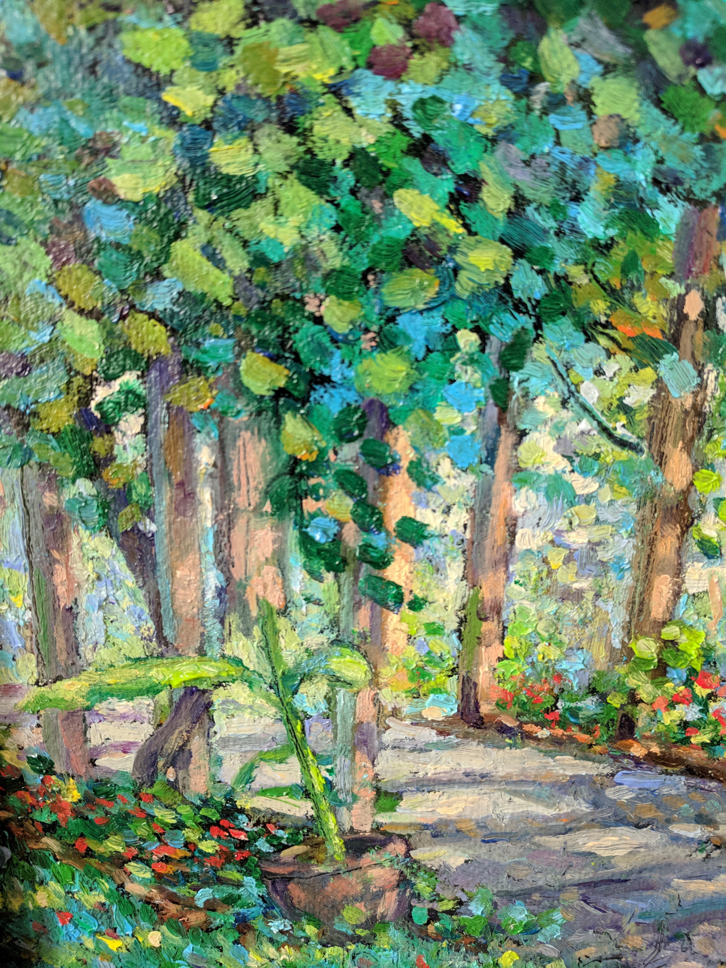 This oil painting on linen is a fine example of an American impressionist landscape by a masterful painter. The painting provides a scene of green and many-hued trees that give an embrace to a stone path. The light filtering through the leaves give