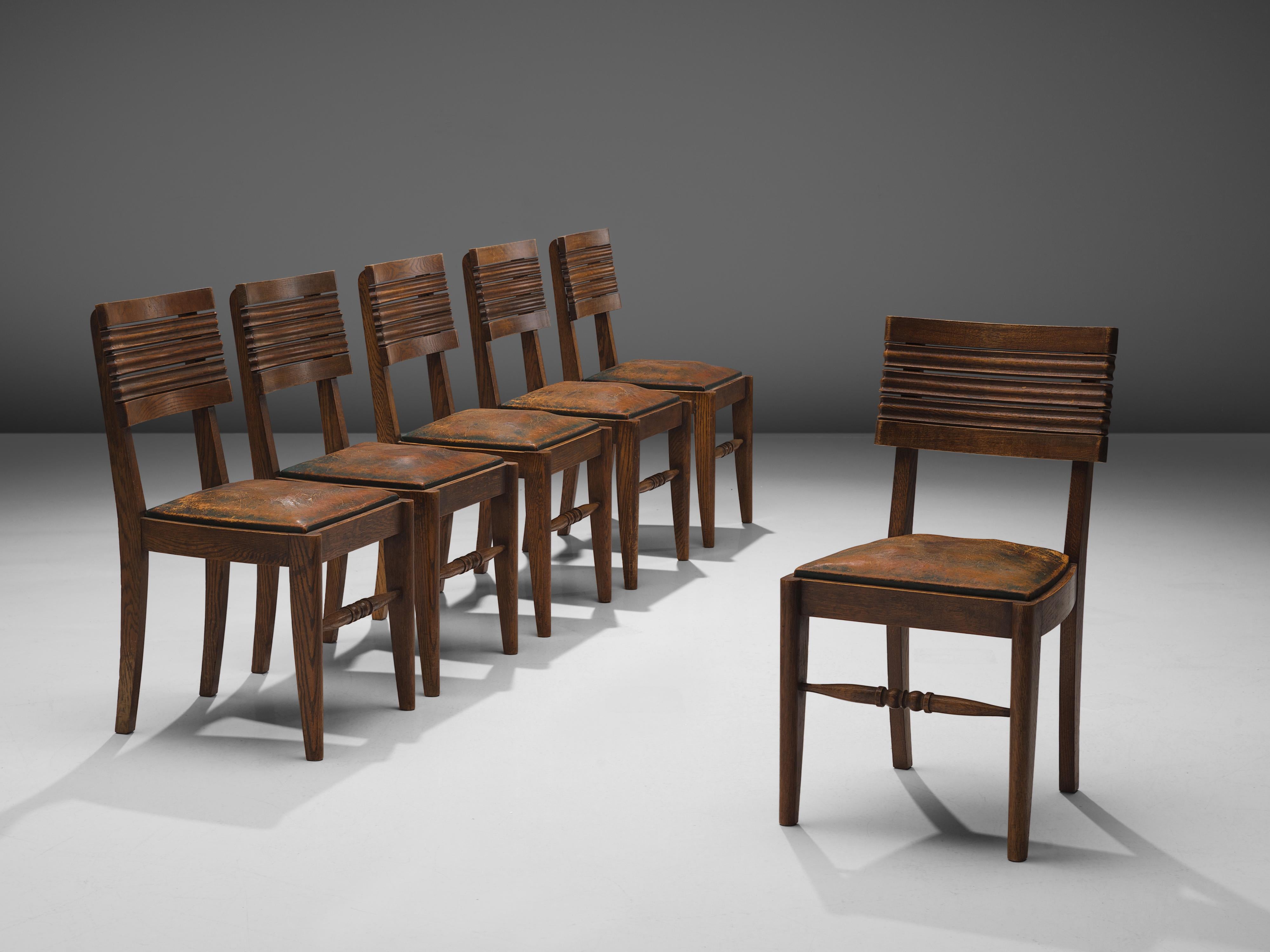 Gaston Poisson, set of six dining chairs, oak, leather, France, 1940s.

Dining chairs in solid oak, with beautiful detailed woodcarving and stunning patinated leather. The back of the chair consist of five slightly curved slats: top and bottom are